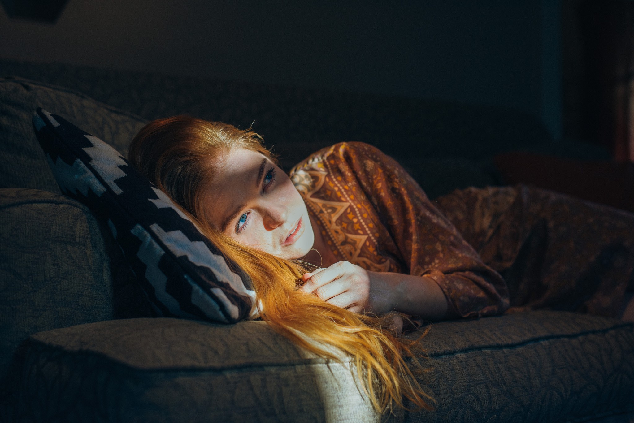 Redhead woman with blue eyes lying on a couch HD Wallpaper