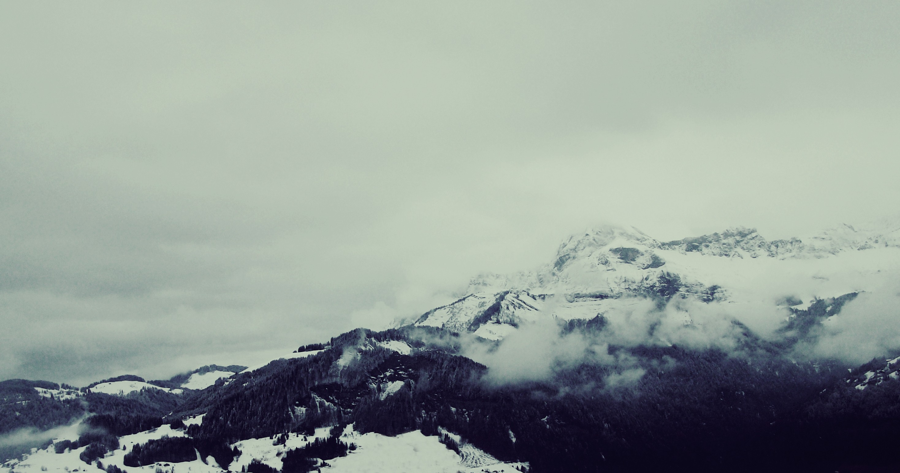 Snow-covered mountains shrouded in clouds HD Wallpaper