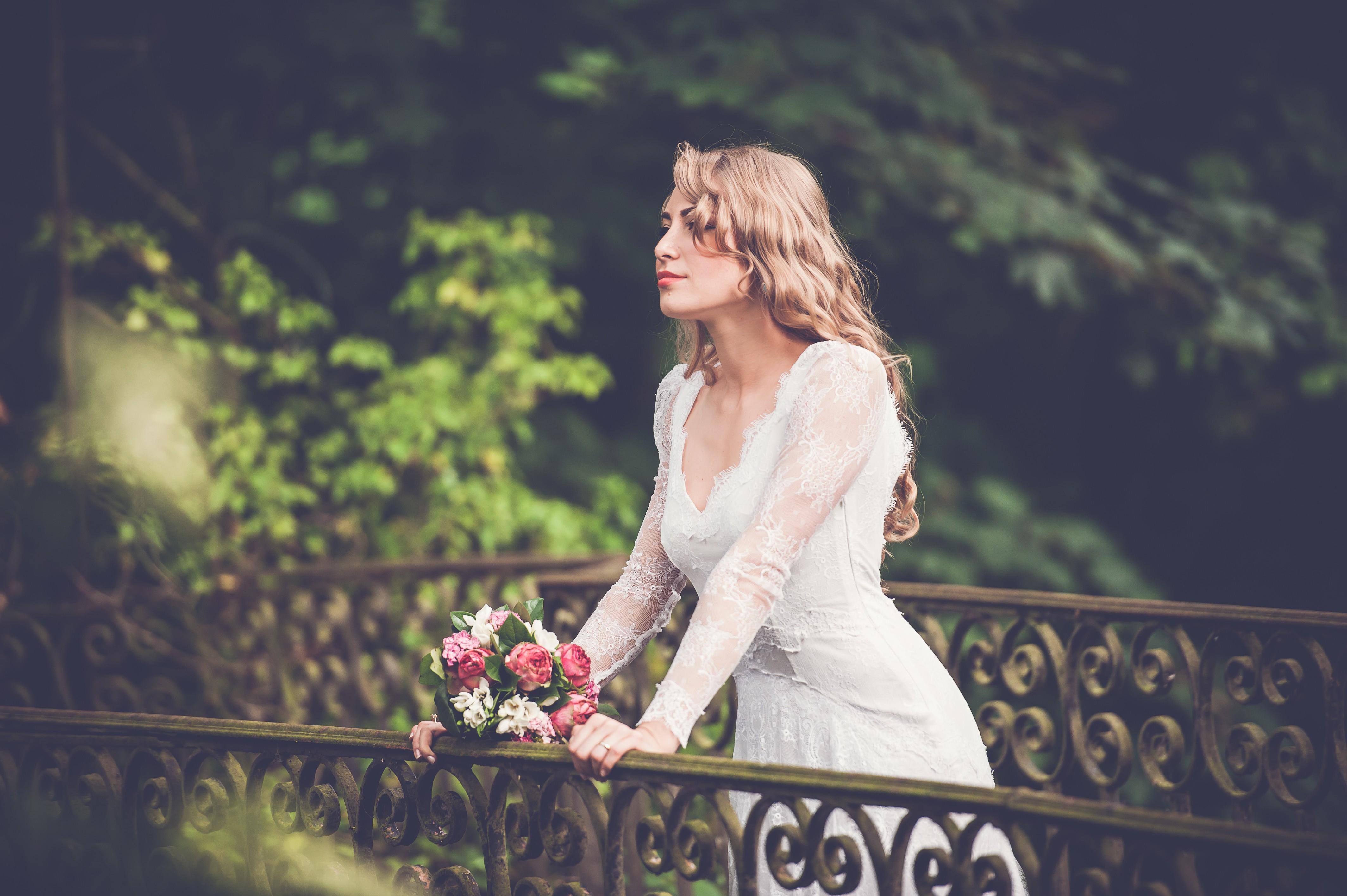 Bride in a white lace dress holding a bouquet HD Wallpaper