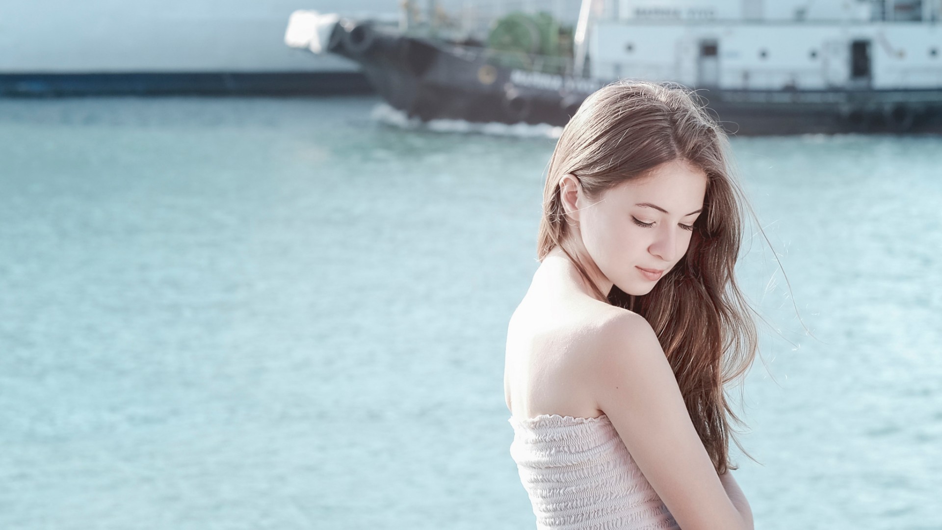Woman with long auburn hair by the water HD Wallpaper
