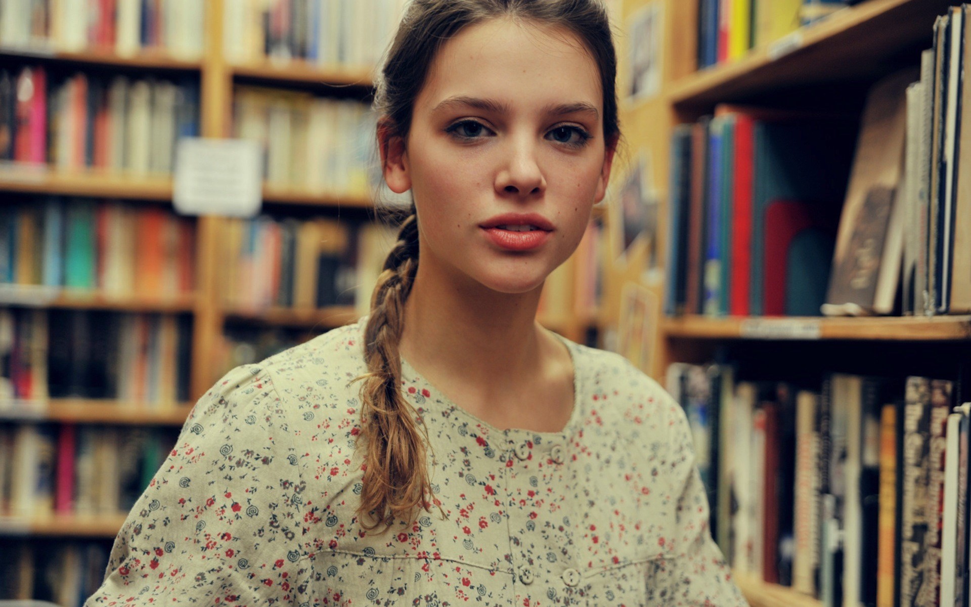 long hair, open mouth, shelves, brunette, Emily Tebbetts, portrait, books, looking at viewer, library, braids, face, model, women, Tessa Schaaf HD Wallpaper