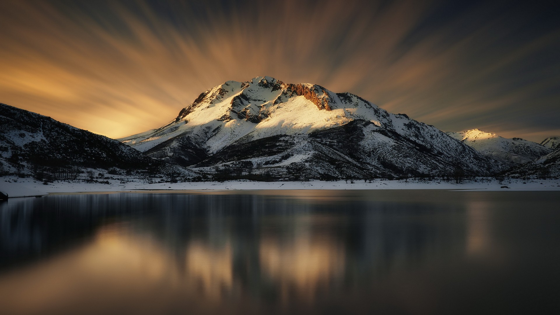 Snow-capped mountains reflected in a lake at sunset HD Wallpaper