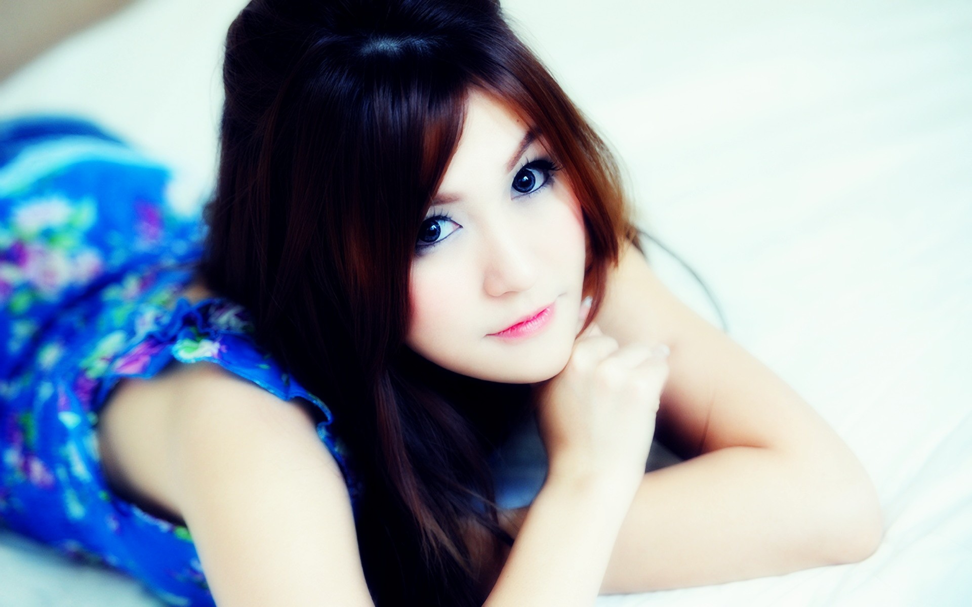 Asian woman lying on a white surface HD Wallpaper