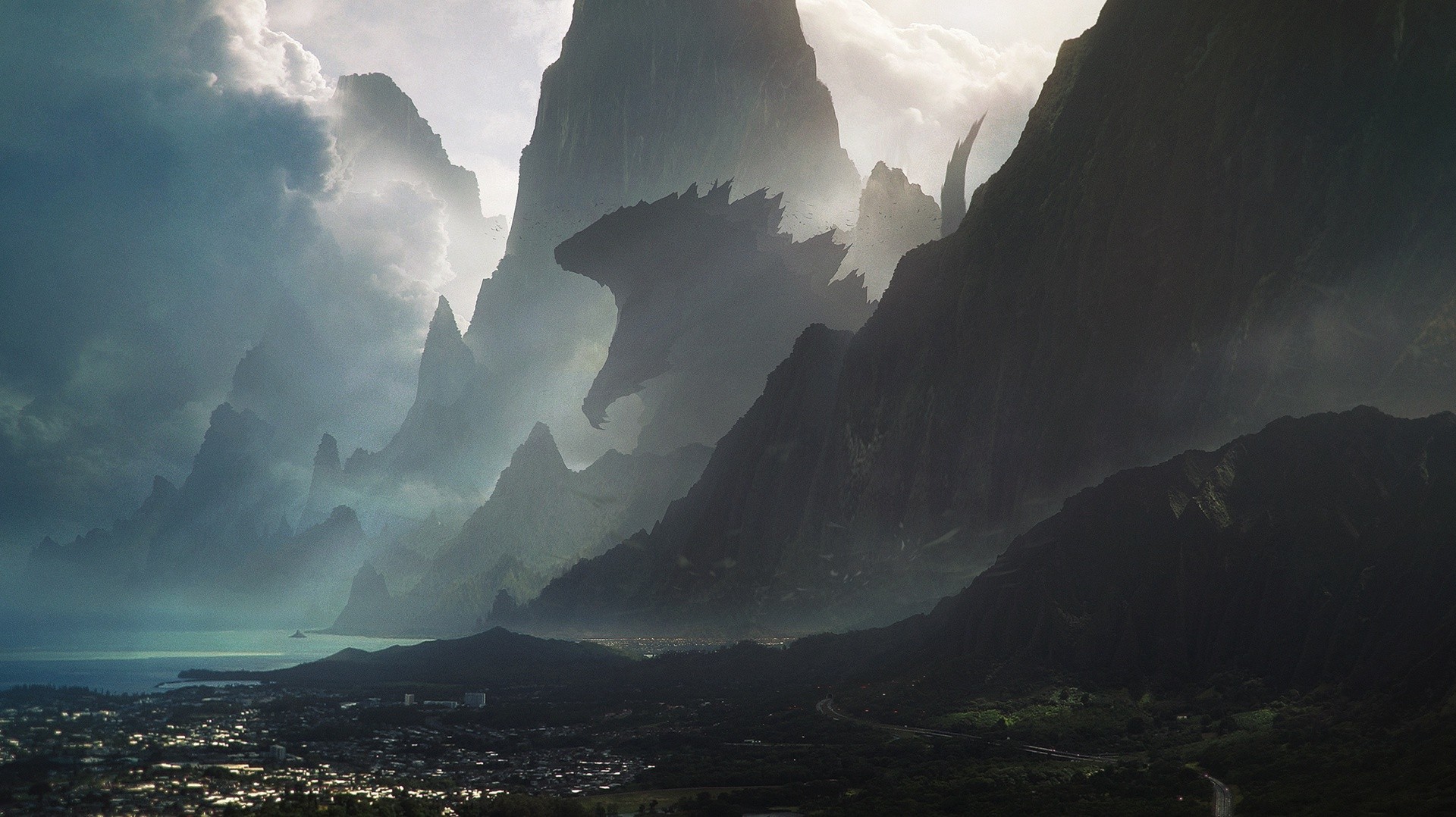 Godzilla silhouette among misty mountains overlooking a town HD Wallpaper