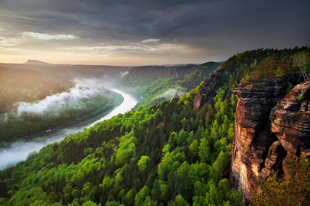 Misty river valley with forest and rock formations at sunset HD Wallpaper