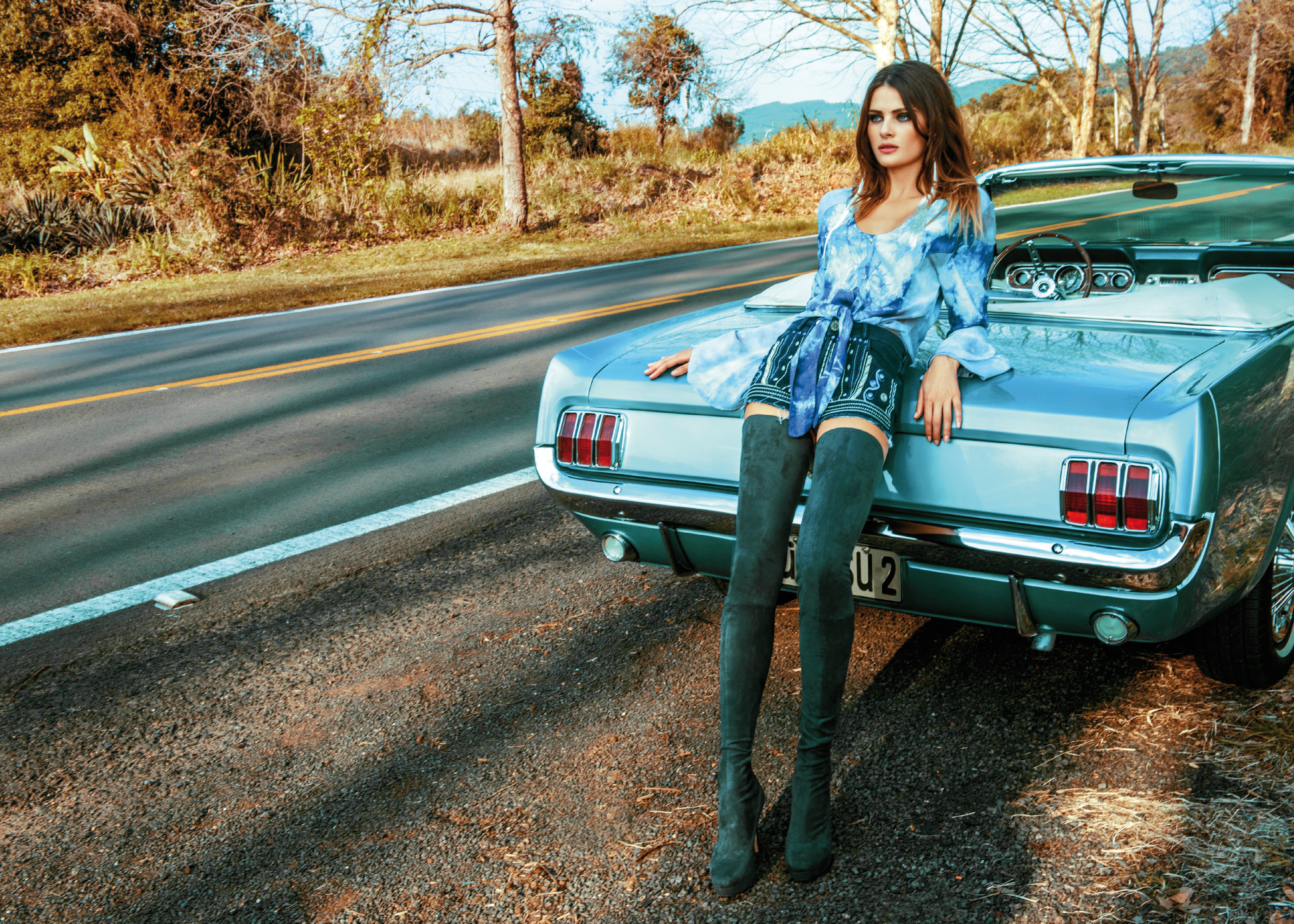 Woman in blue top and suede stockings leaning on a classic car HD Wallpaper