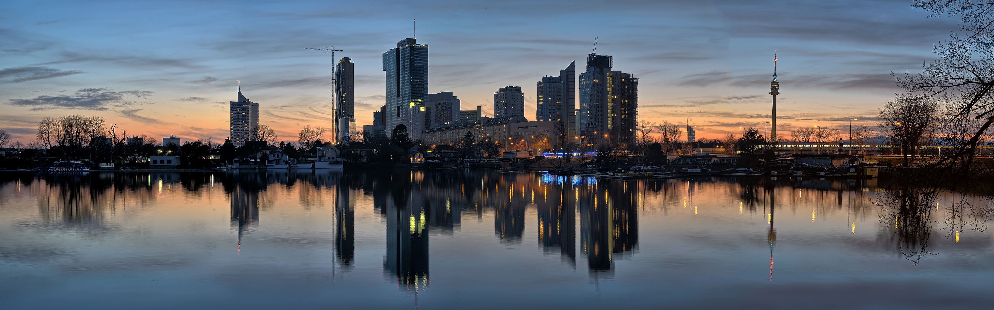 Vienna skyline reflected in the Danube River at dusk HD Wallpaper