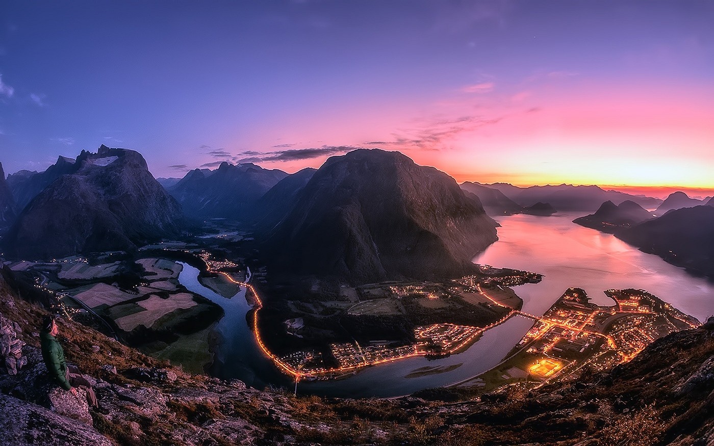 Sunset over a Norwegian fjord with a town and mountains HD Wallpaper