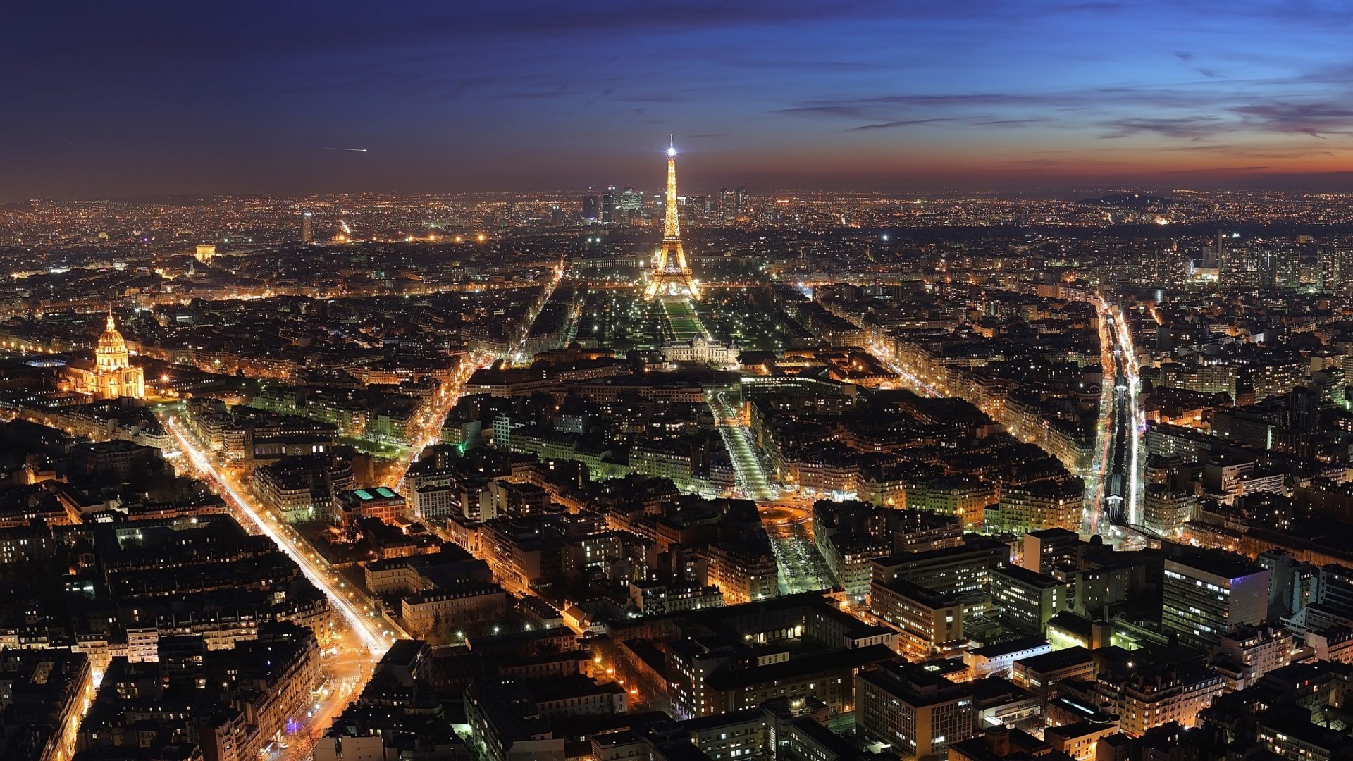 Eiffel Tower illuminated at dusk over Paris cityscape HD Wallpaper