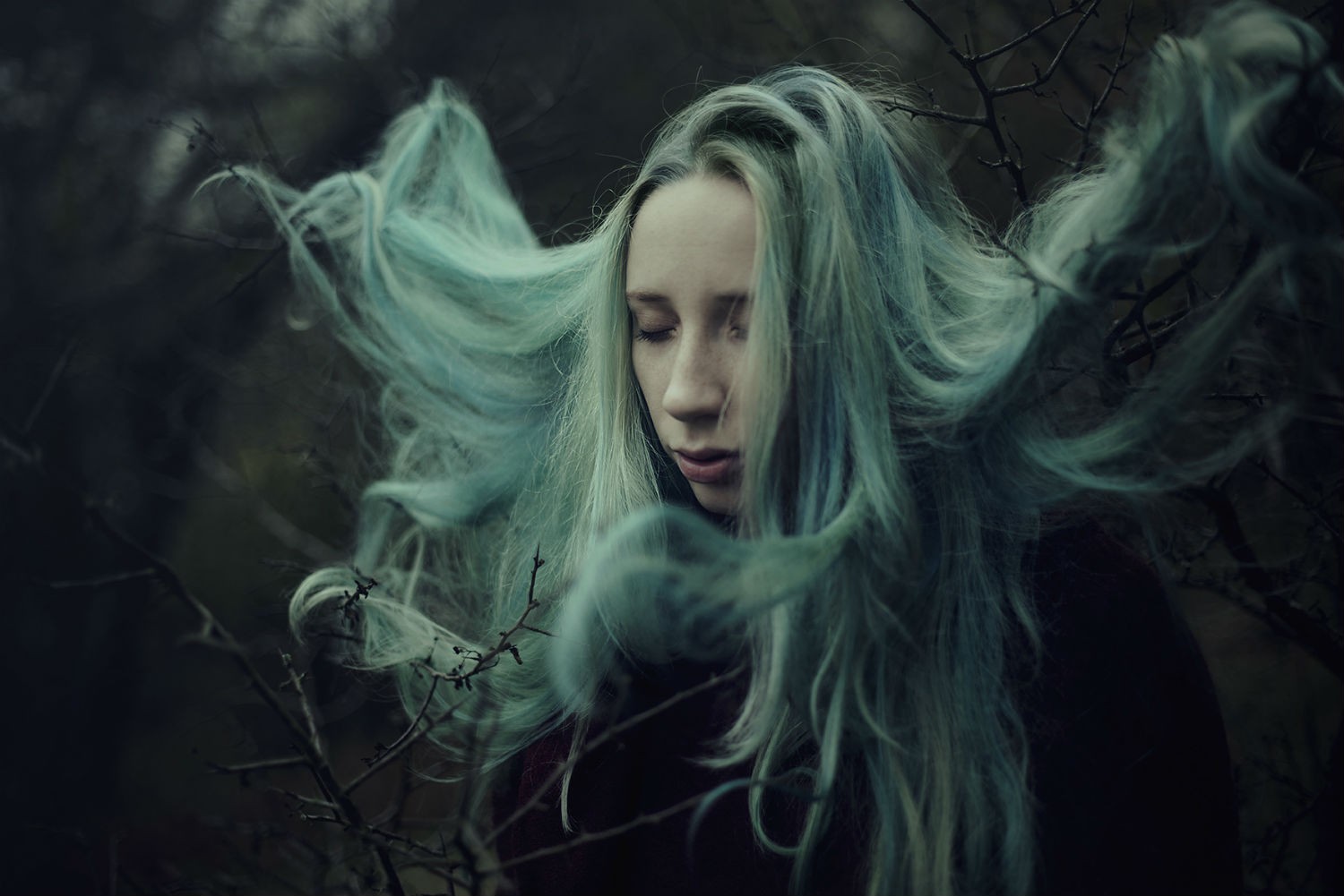Woman with flowing blue hair in a dark forest HD Wallpaper