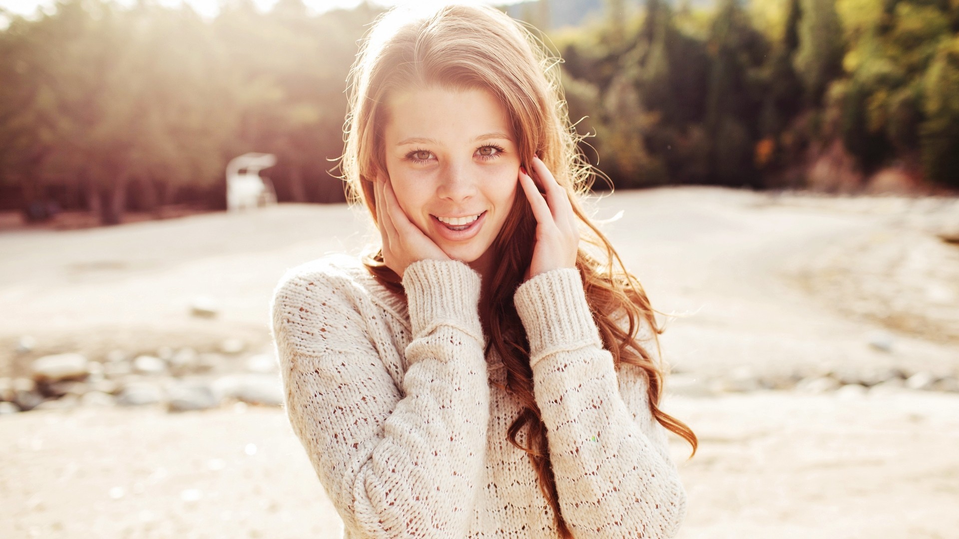 Young woman with long brown hair smiling outdoors HD Wallpaper