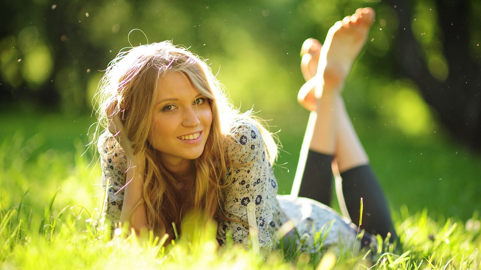 Young blonde woman lying in grass HD Wallpaper