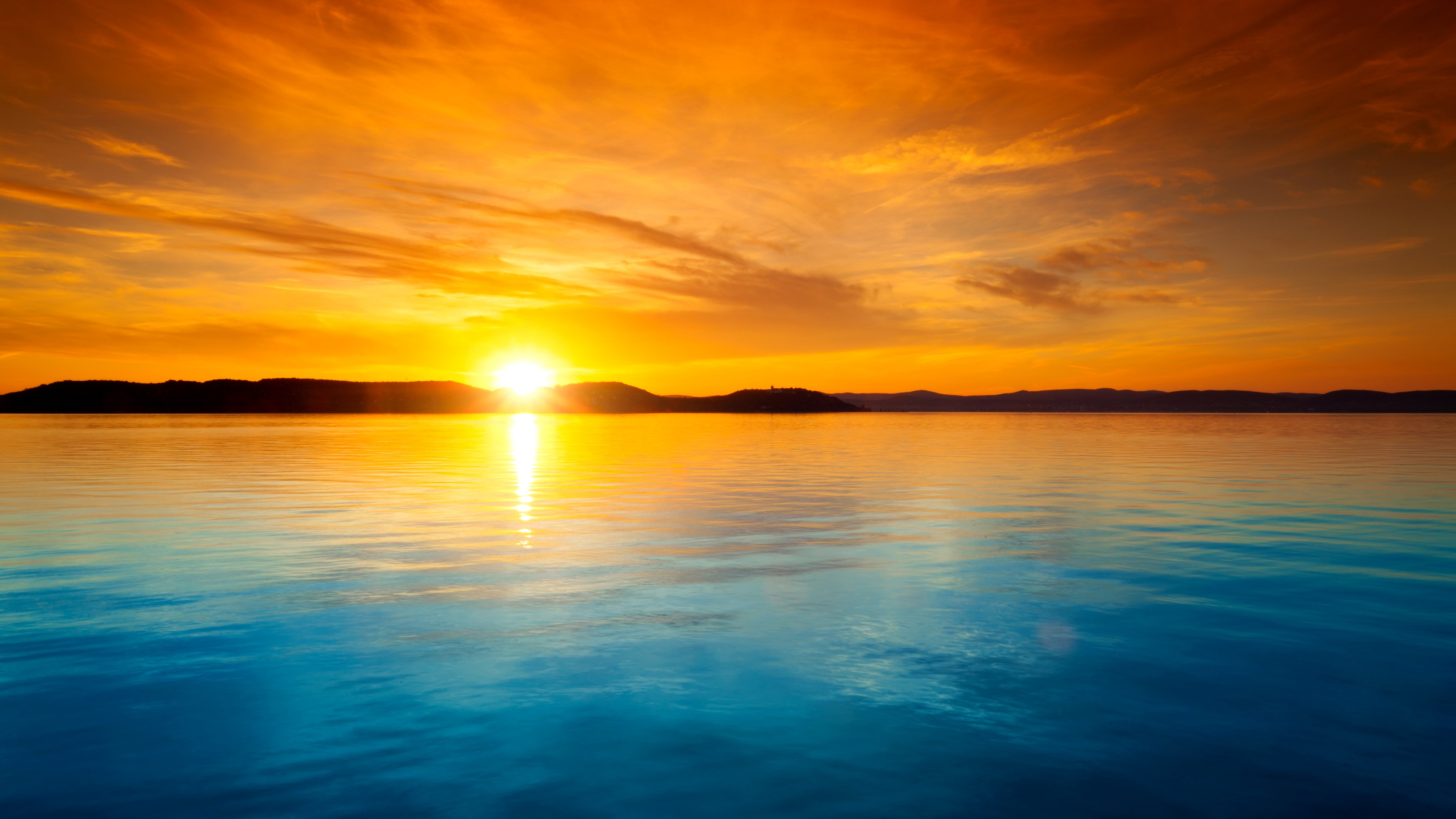 Sunset over the horizon with calm water HD Wallpaper