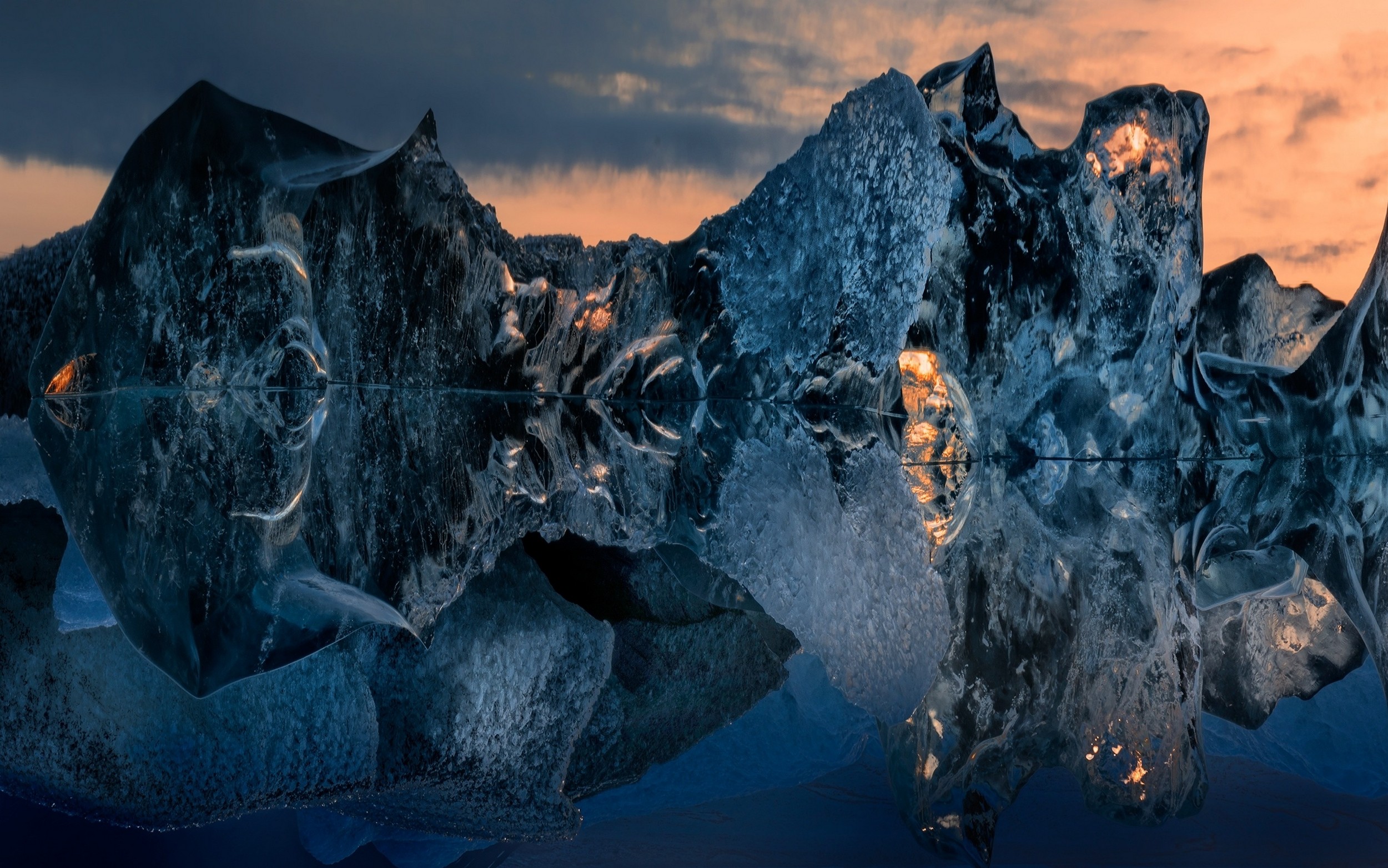 Iceberg sculptures reflecting in water at sunset HD Wallpaper