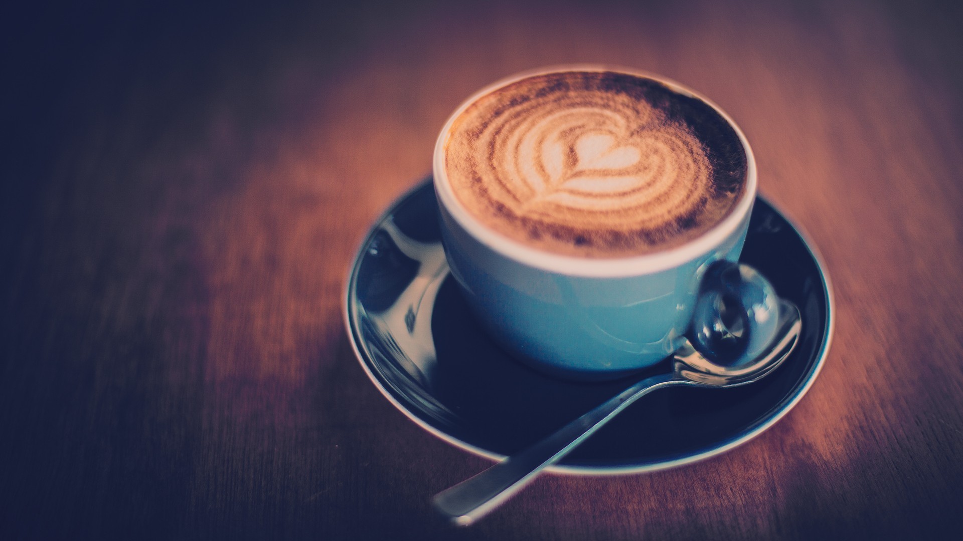 Latte art coffee in a blue cup with a spoon HD Wallpaper