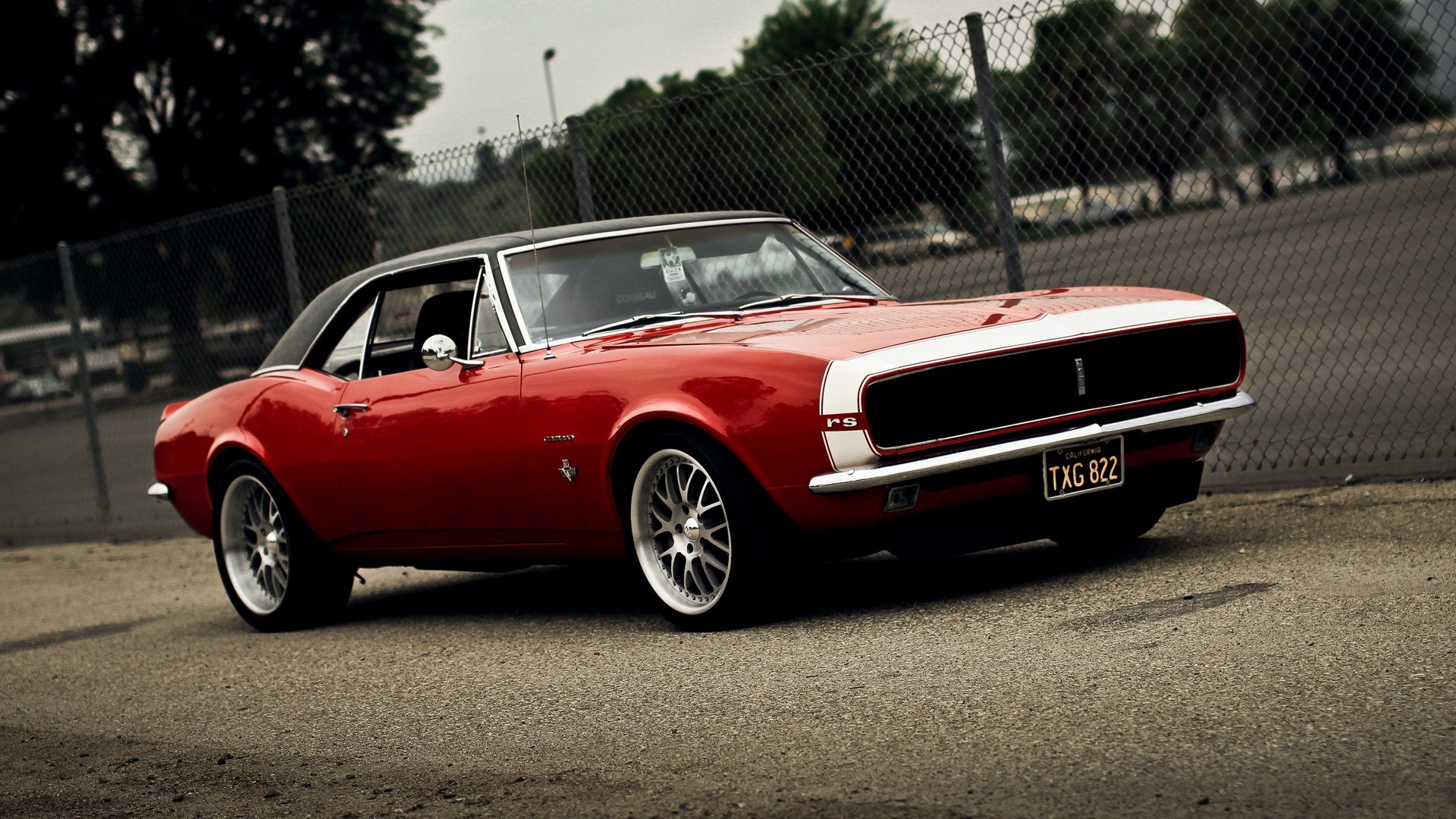 Red 1967 Chevrolet Camaro RS parked near a fence HD Wallpaper