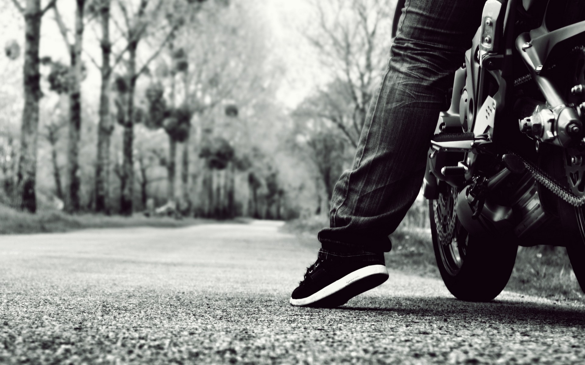 Monochrome shot of a person on a motorcycle on a road HD Wallpaper