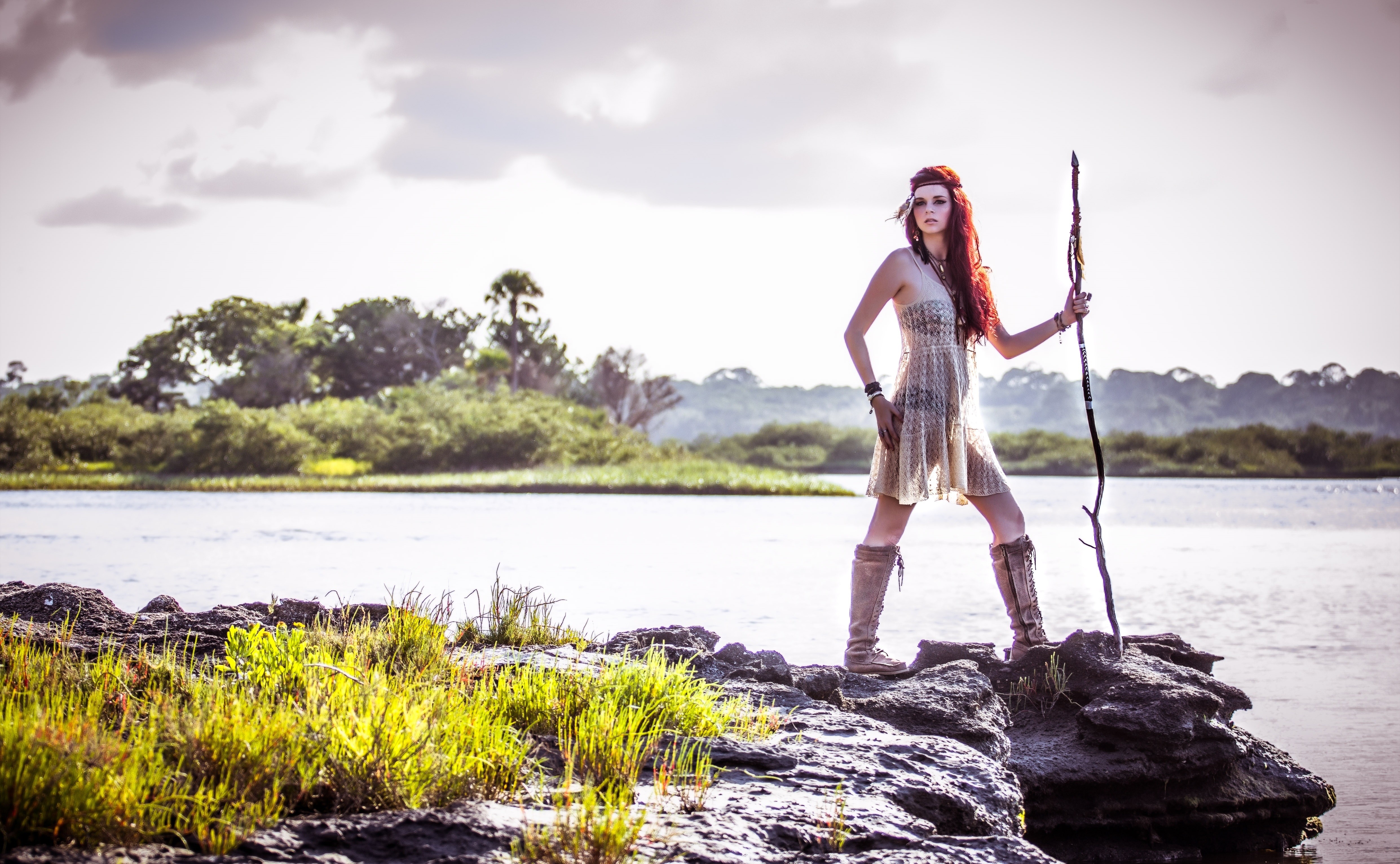 Redhead woman with staff on rocks by water HD Wallpaper