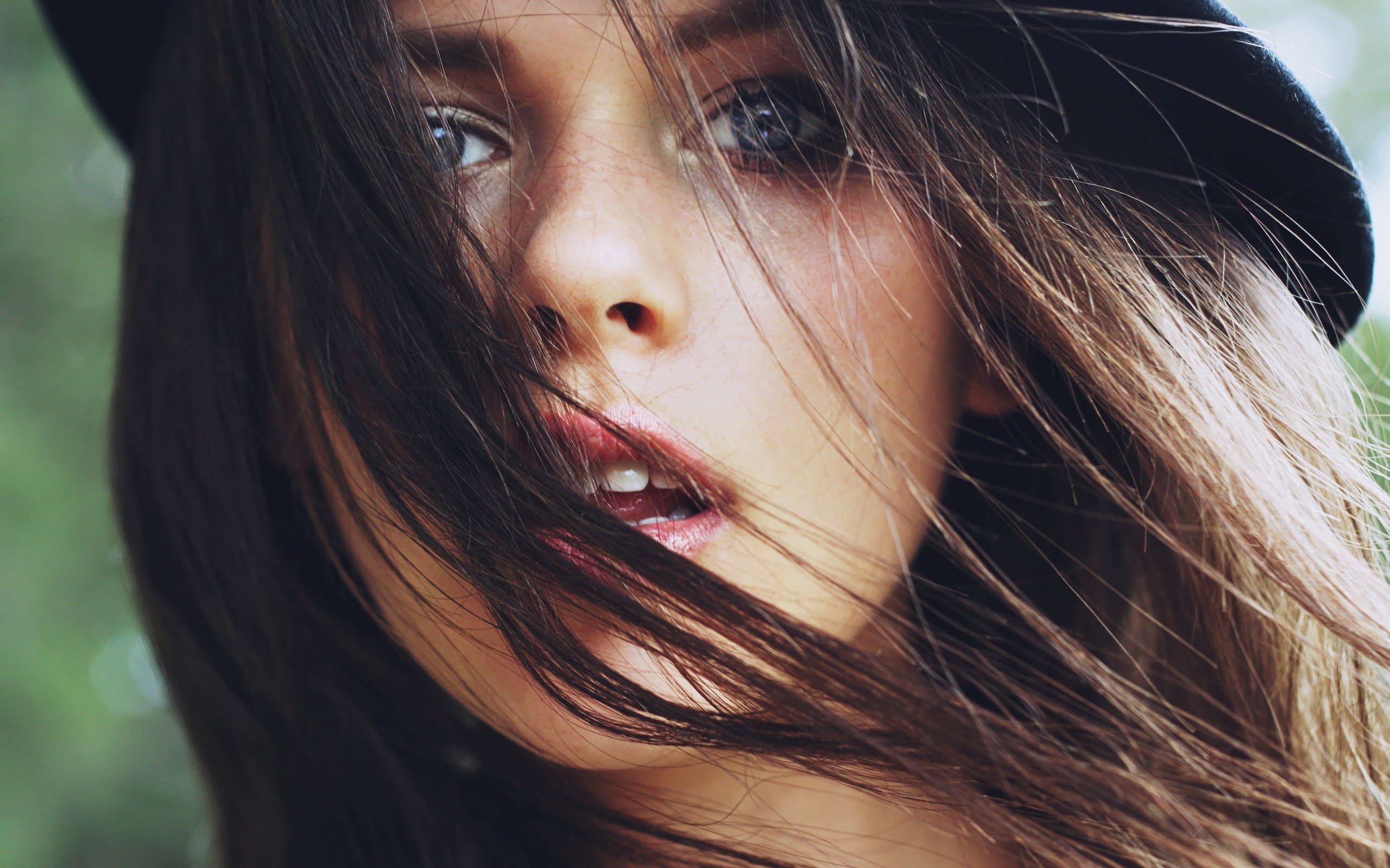 Brunette woman wearing a hat with hair blowing HD Wallpaper