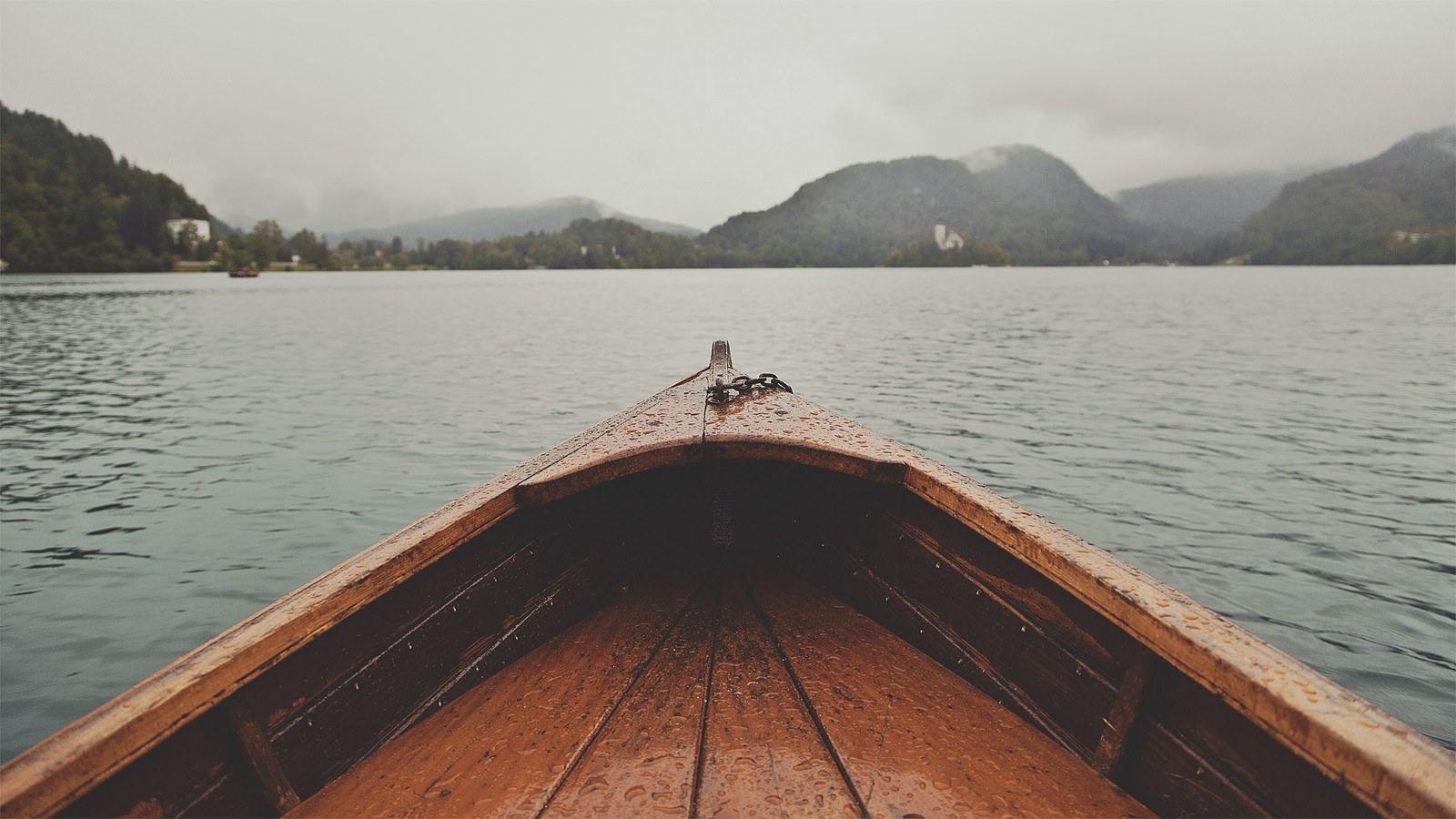 Boat on a lake with mountains in the background HD Wallpaper
