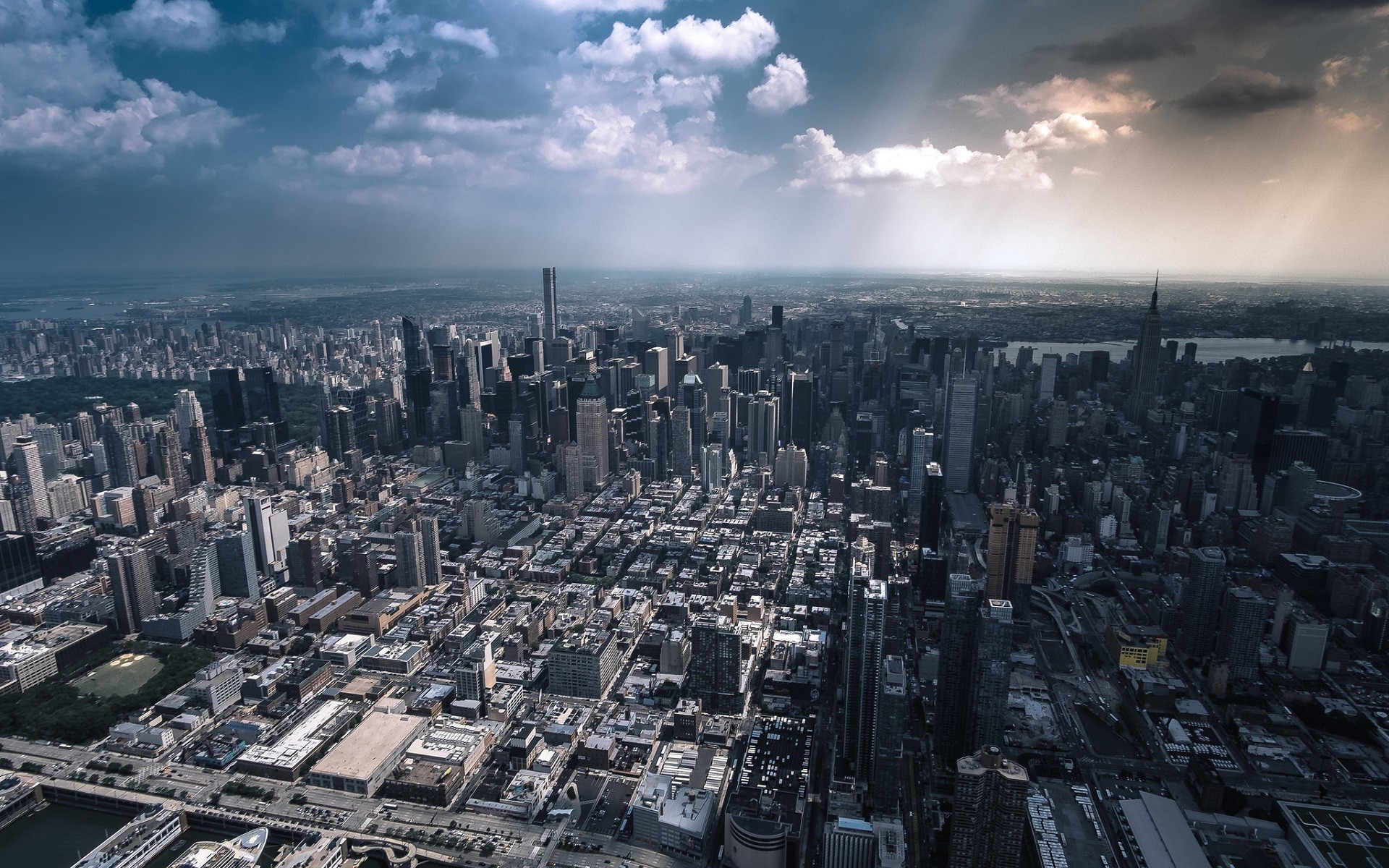Aerial view of New York City skyscrapers under dramatic clouds HD Wallpaper