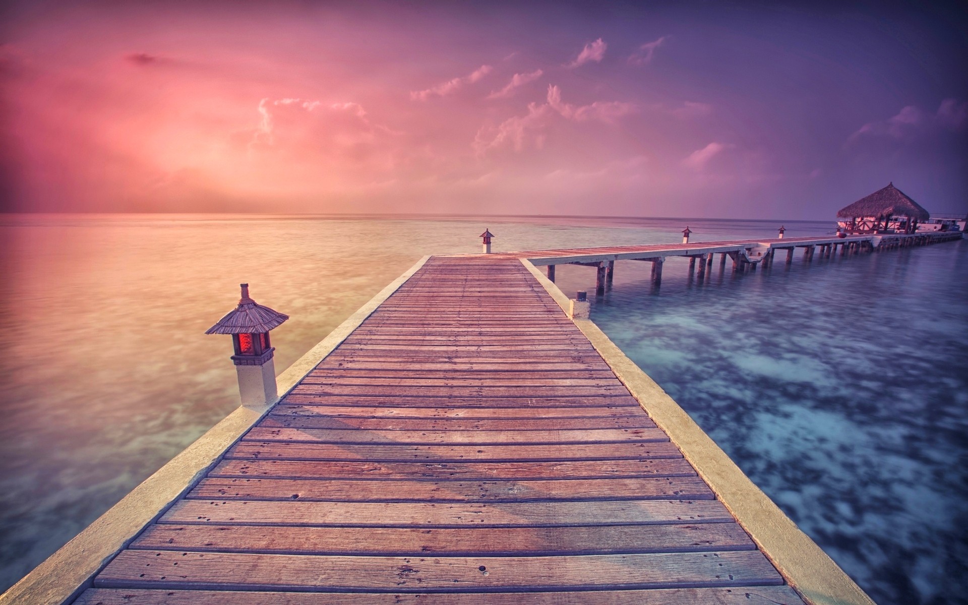 Wooden pier with lights over the ocean at sunset HD Wallpaper