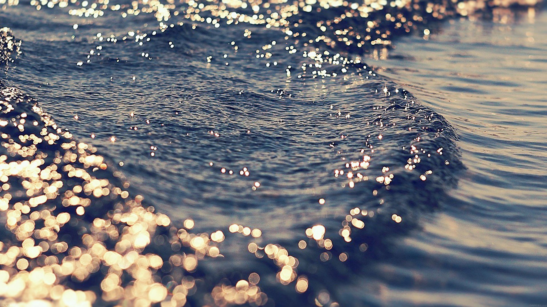 Sparkling blue sea waves with golden light reflections HD Wallpaper