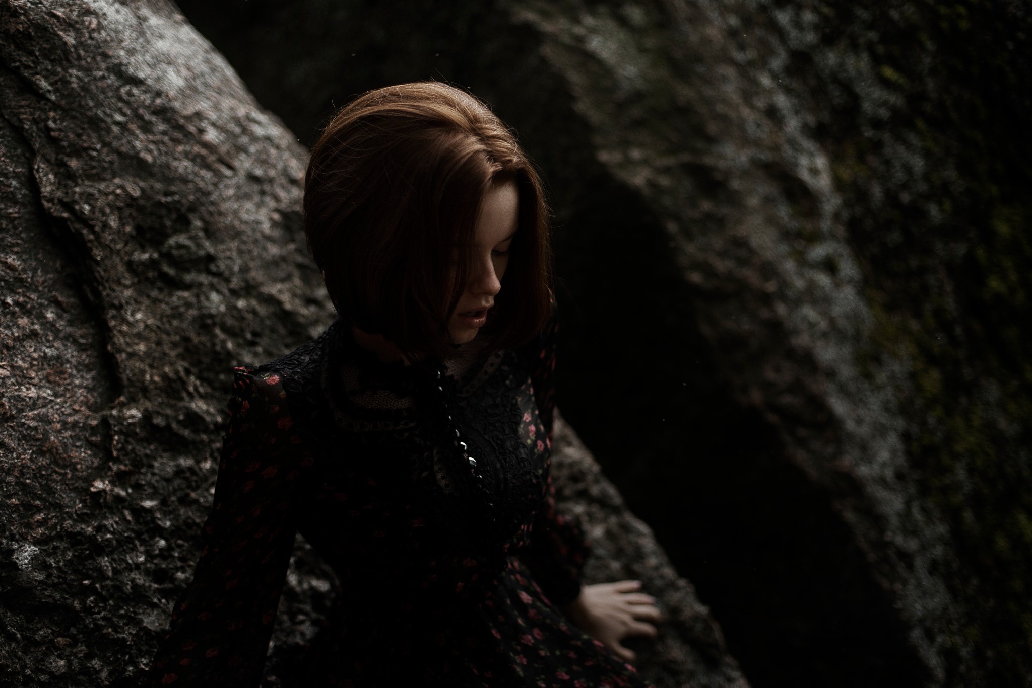 Woman in a dark dress by rocks HD Wallpaper