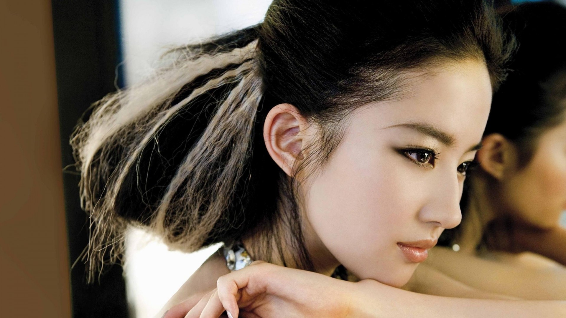 Asian woman with styled hair in a close-up portrait HD Wallpaper