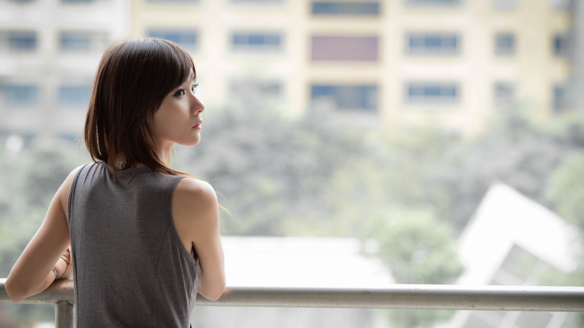 Asian woman looking out from a balcony HD Wallpaper