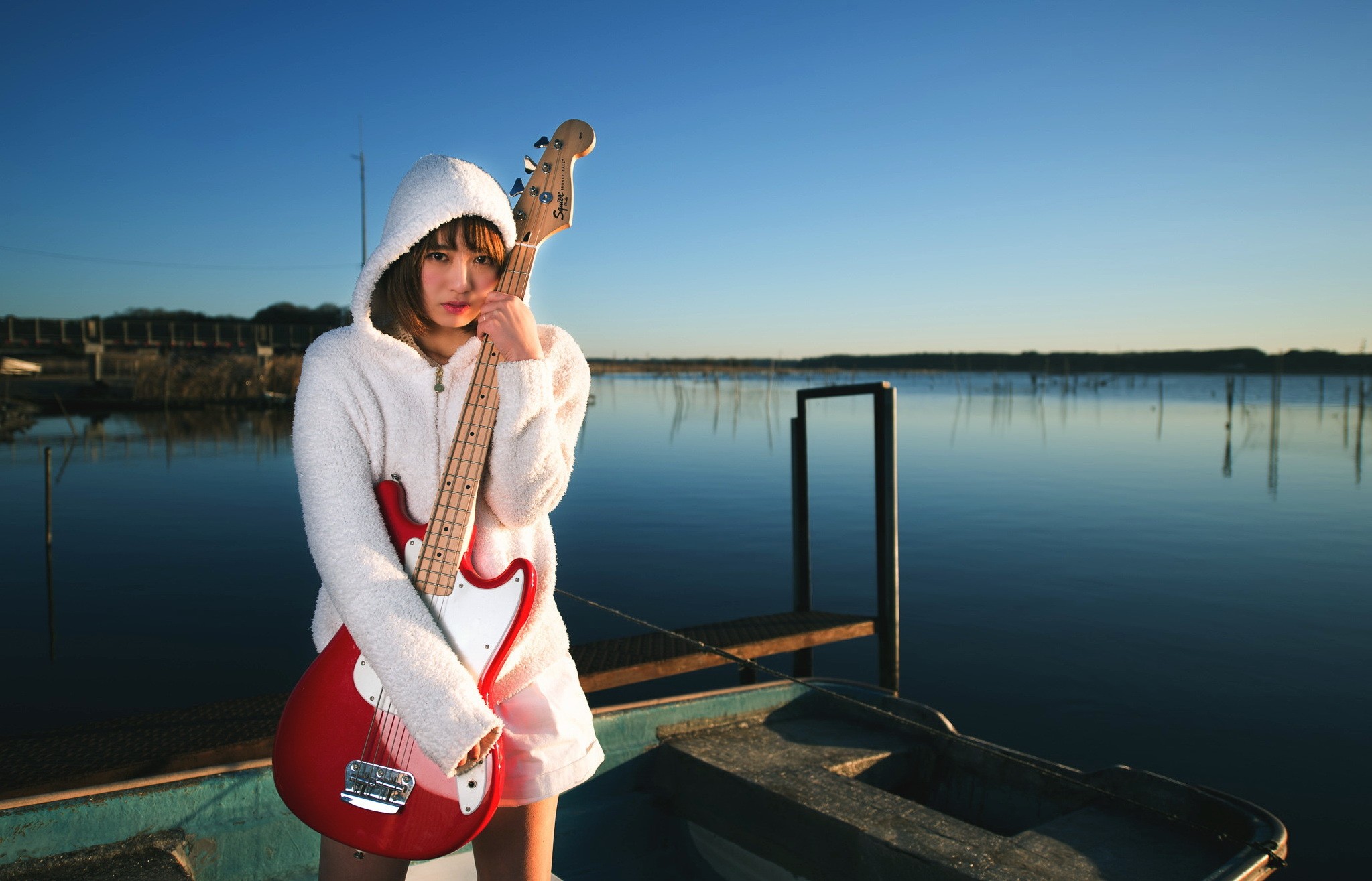 Asian woman in white hoodie holding a red bass guitar HD Wallpaper