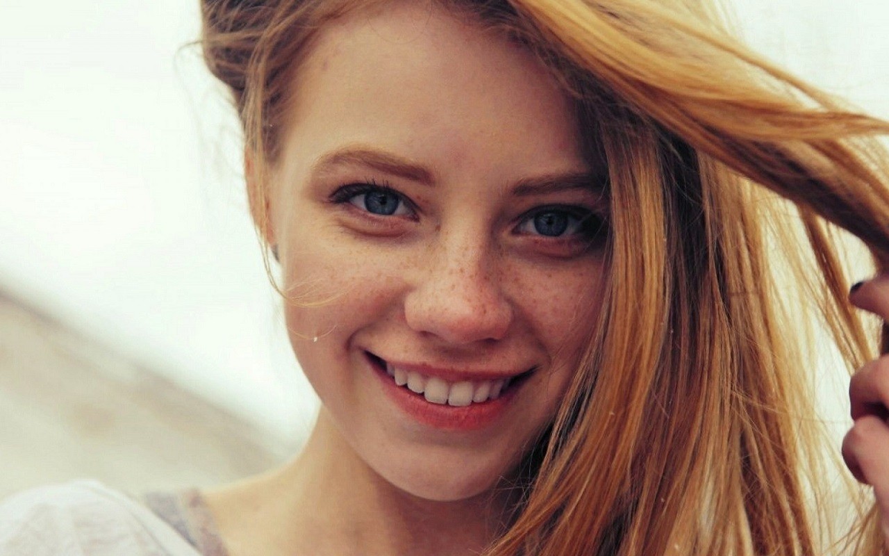Young woman with red hair and freckles smiling HD Wallpaper