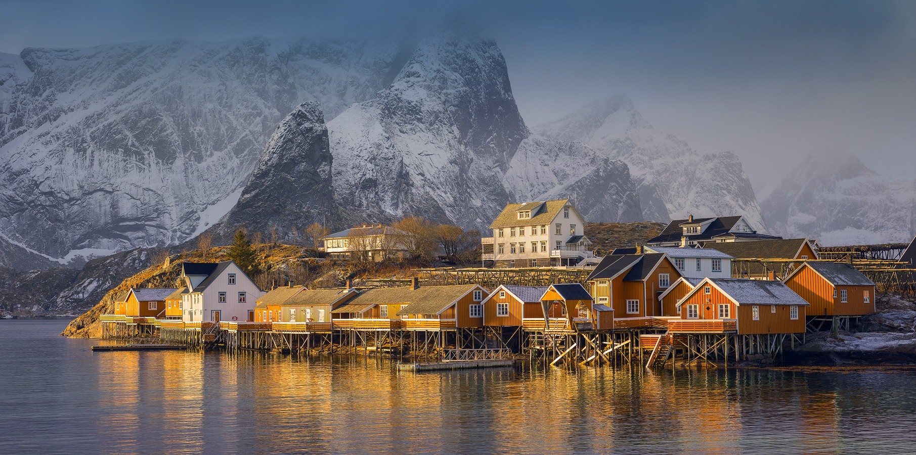 Norwegian village with colorful houses on stilts and snowy mountains HD Wallpaper
