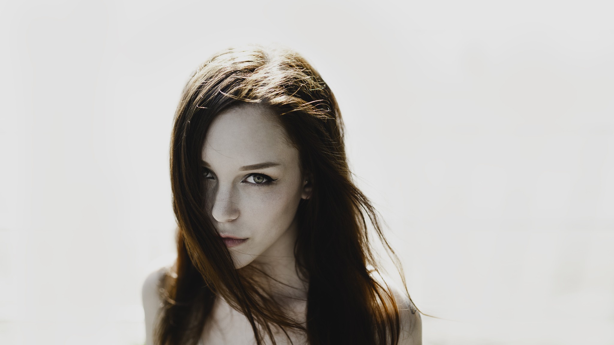 Woman with long brown hair against a white background HD Wallpaper