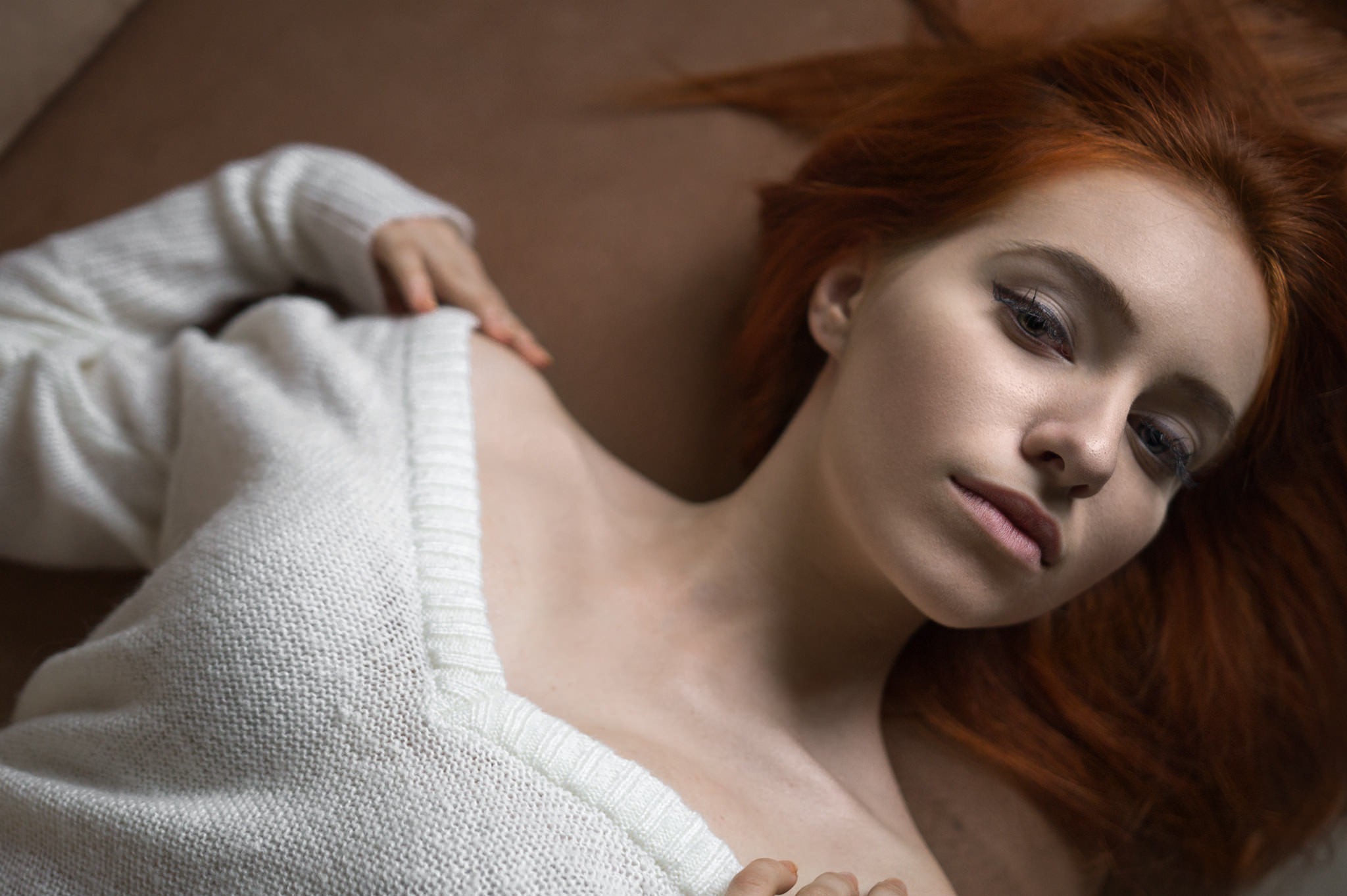 Redhead woman in white sweater lying down HD Wallpaper