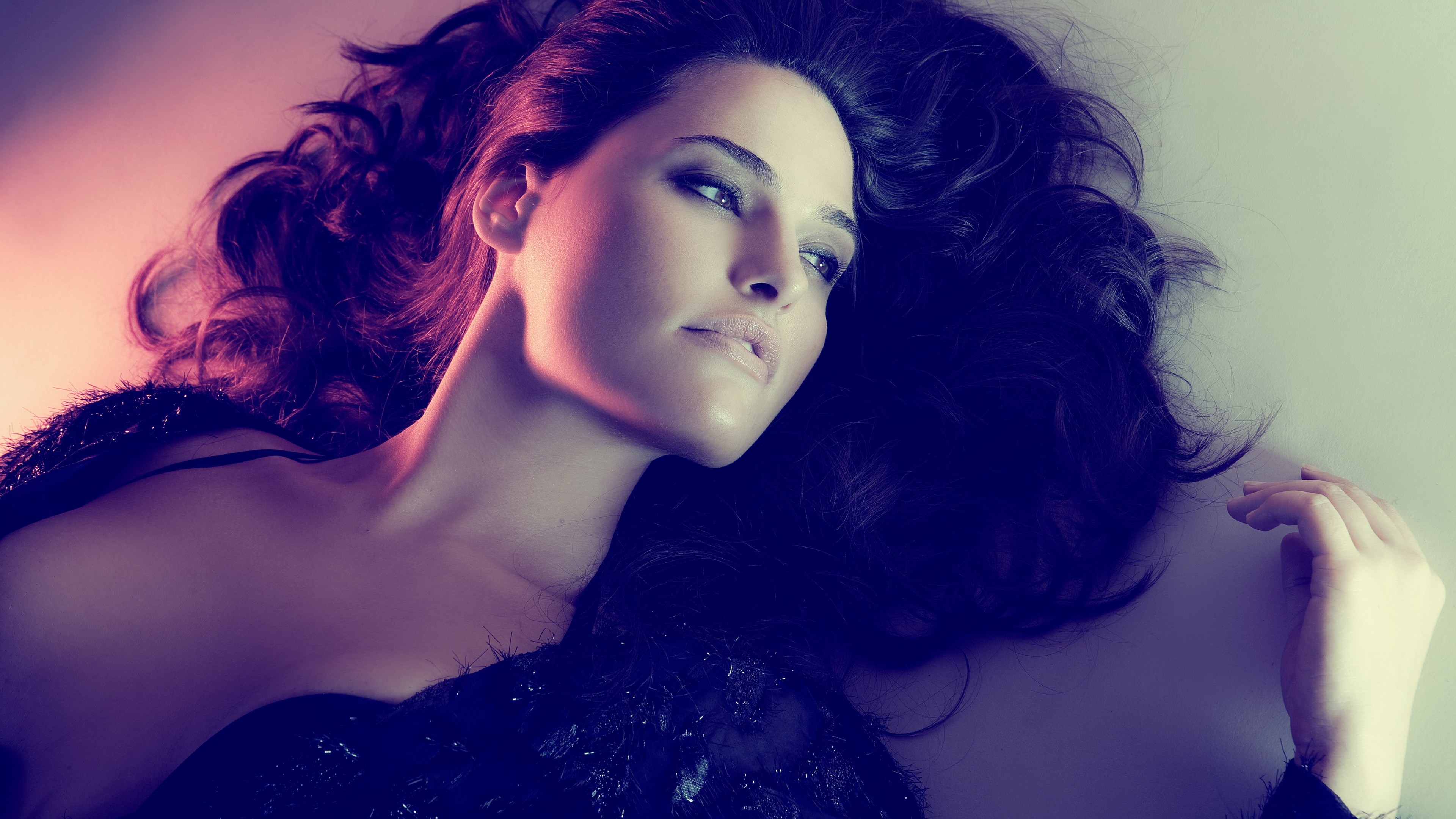 Woman with dark hair and brown eyes lying down HD Wallpaper