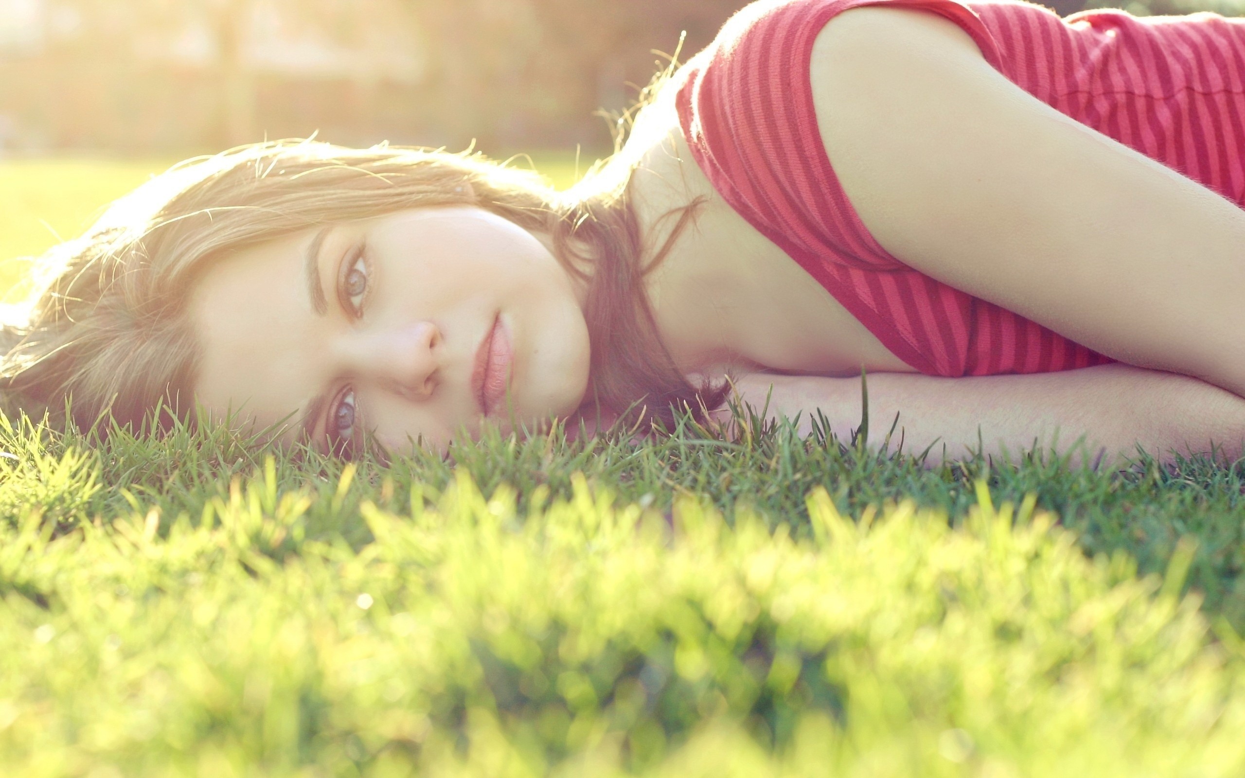 Woman lying on grass in sunlight HD Wallpaper