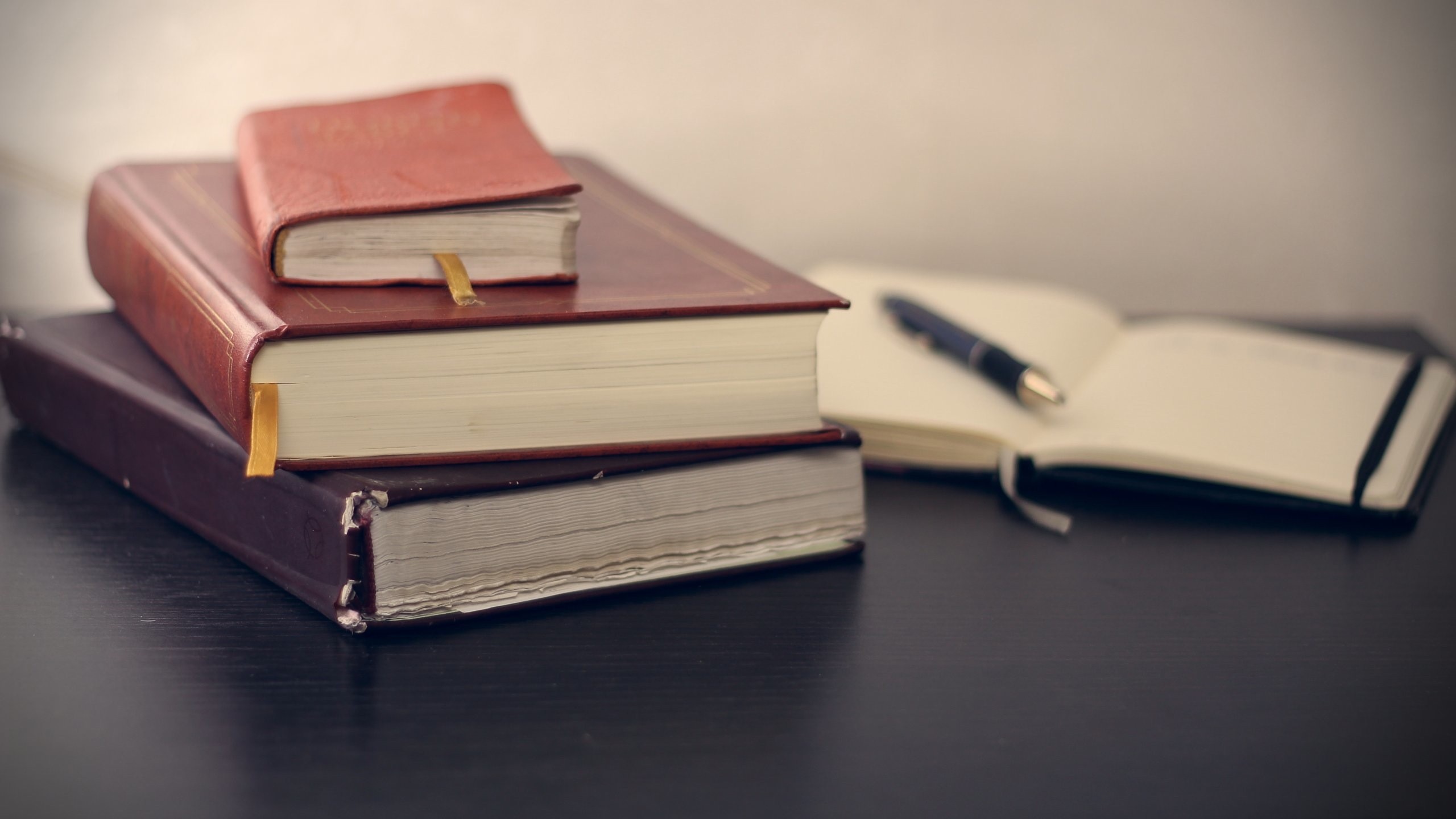 Stack of books and open notebook with pen HD Wallpaper