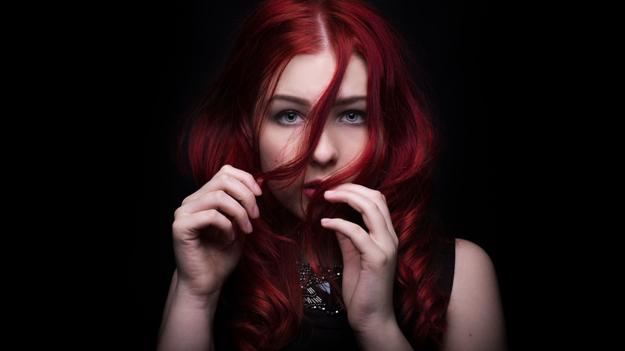 Woman with vibrant red hair against a black background HD Wallpaper