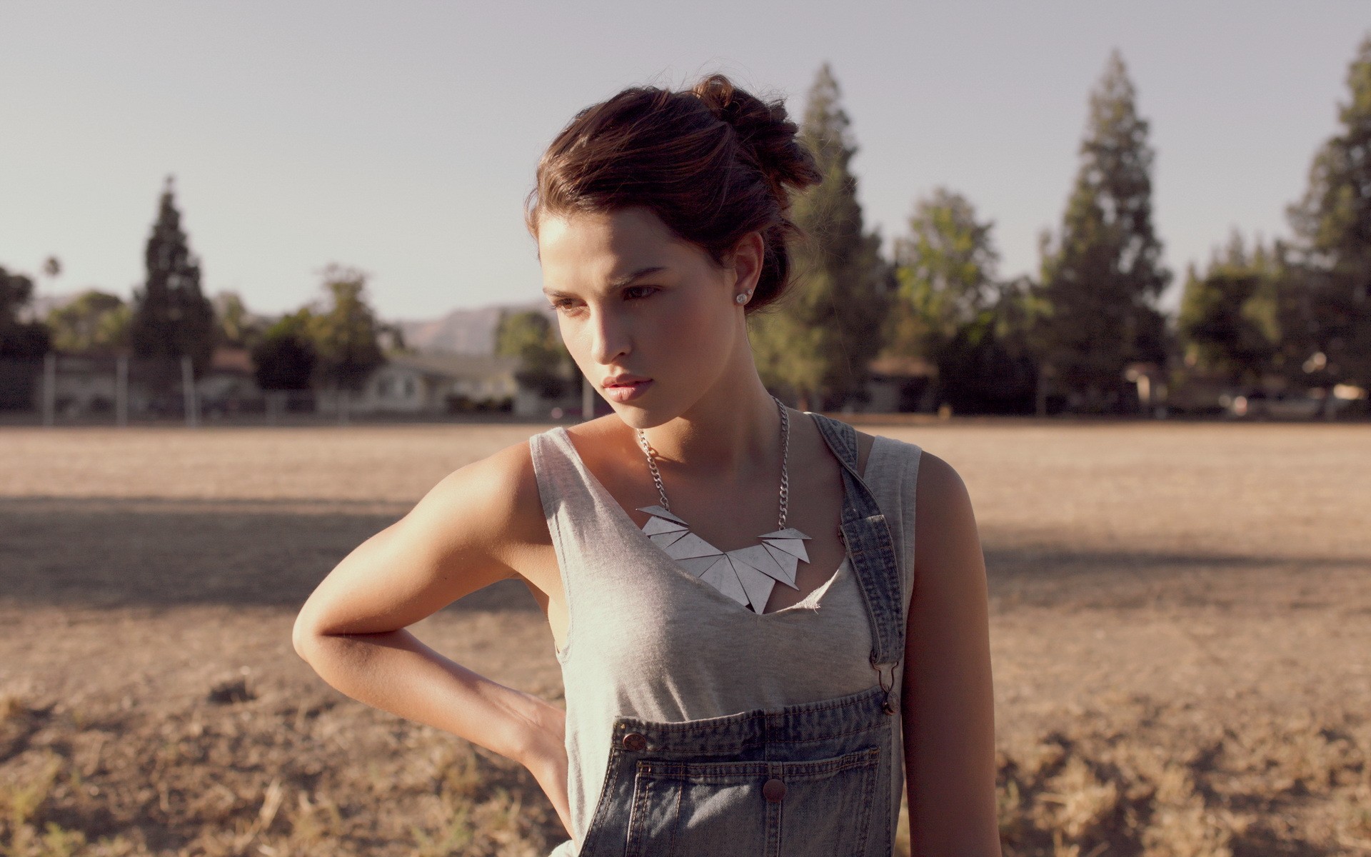 Woman wearing overalls and necklace outdoors HD Wallpaper
