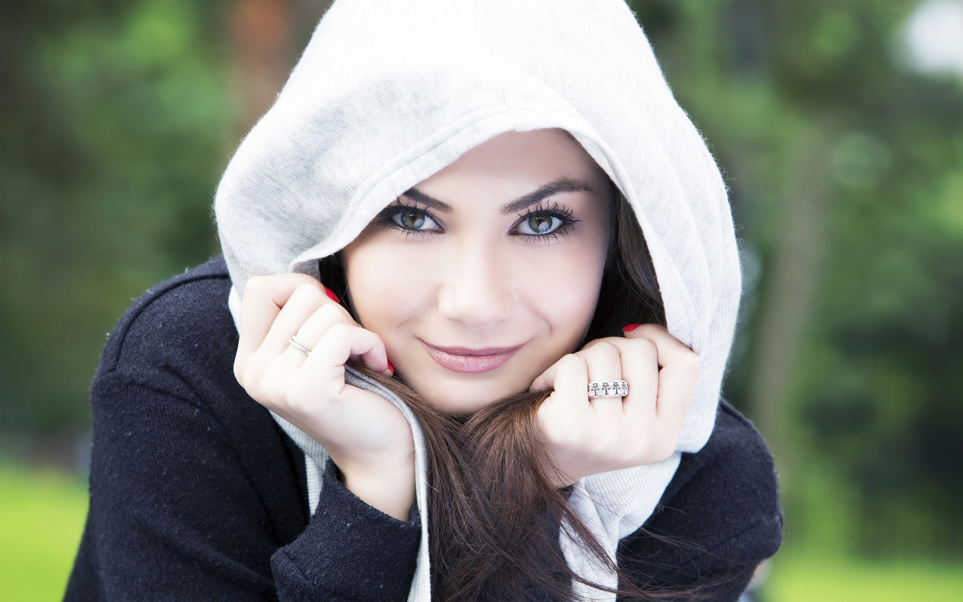 Young woman wearing a hoodie outdoors HD Wallpaper