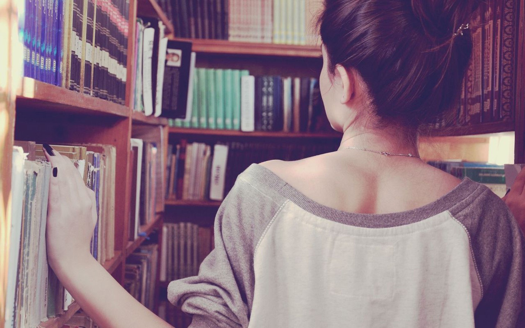Woman browsing books in a library HD Wallpaper