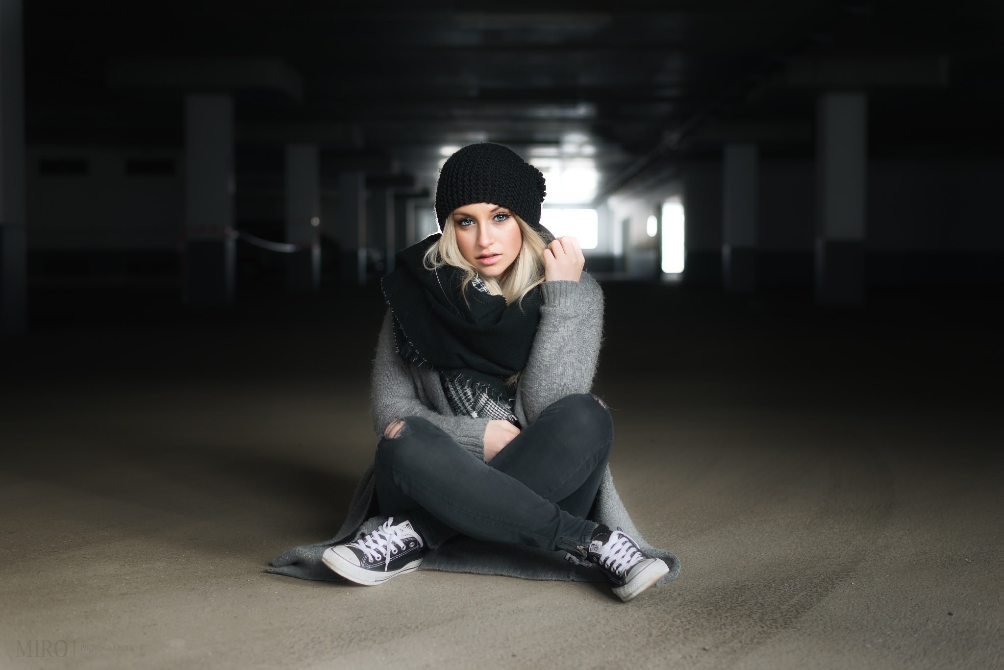 Woman in black beanie and grey sweater sitting on floor HD Wallpaper