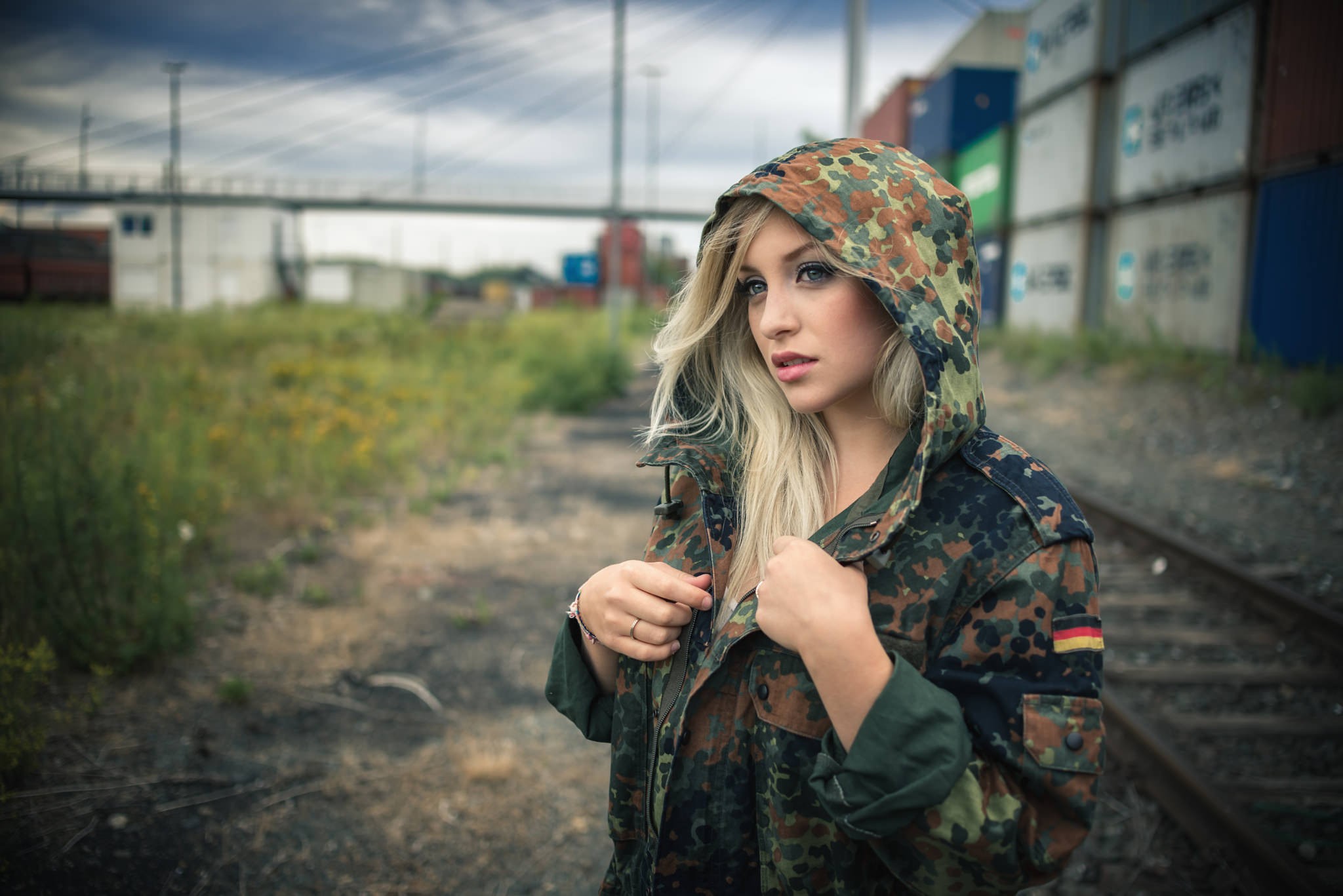 Woman in camouflage jacket with blonde hair HD Wallpaper