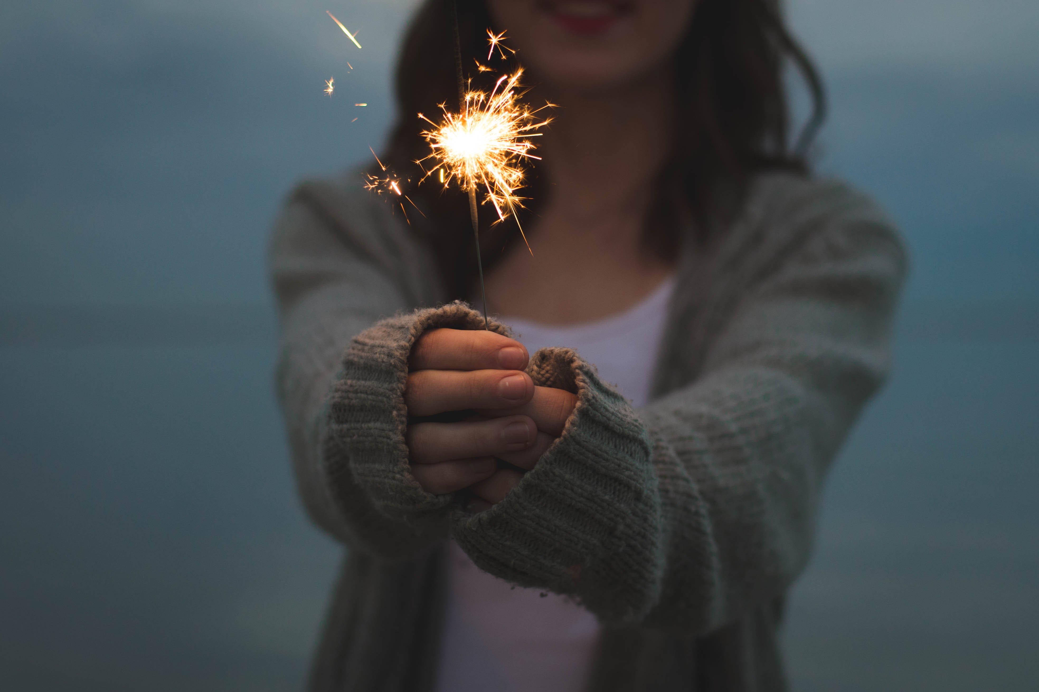 Woman holding a sparkler outdoors HD Wallpaper