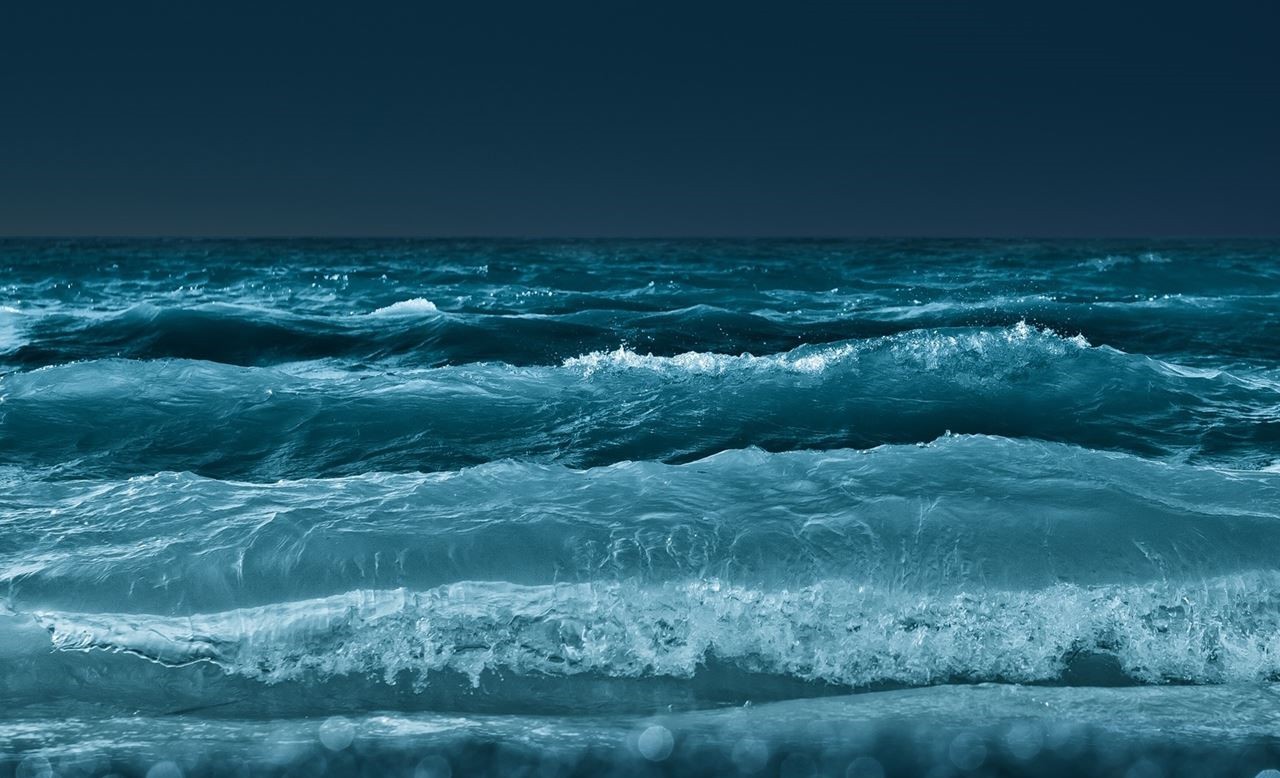 Ocean waves crashing under a dark sky HD Wallpaper