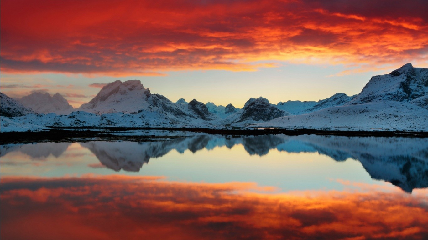 Snowy mountains reflected in calm water at sunset HD Wallpaper