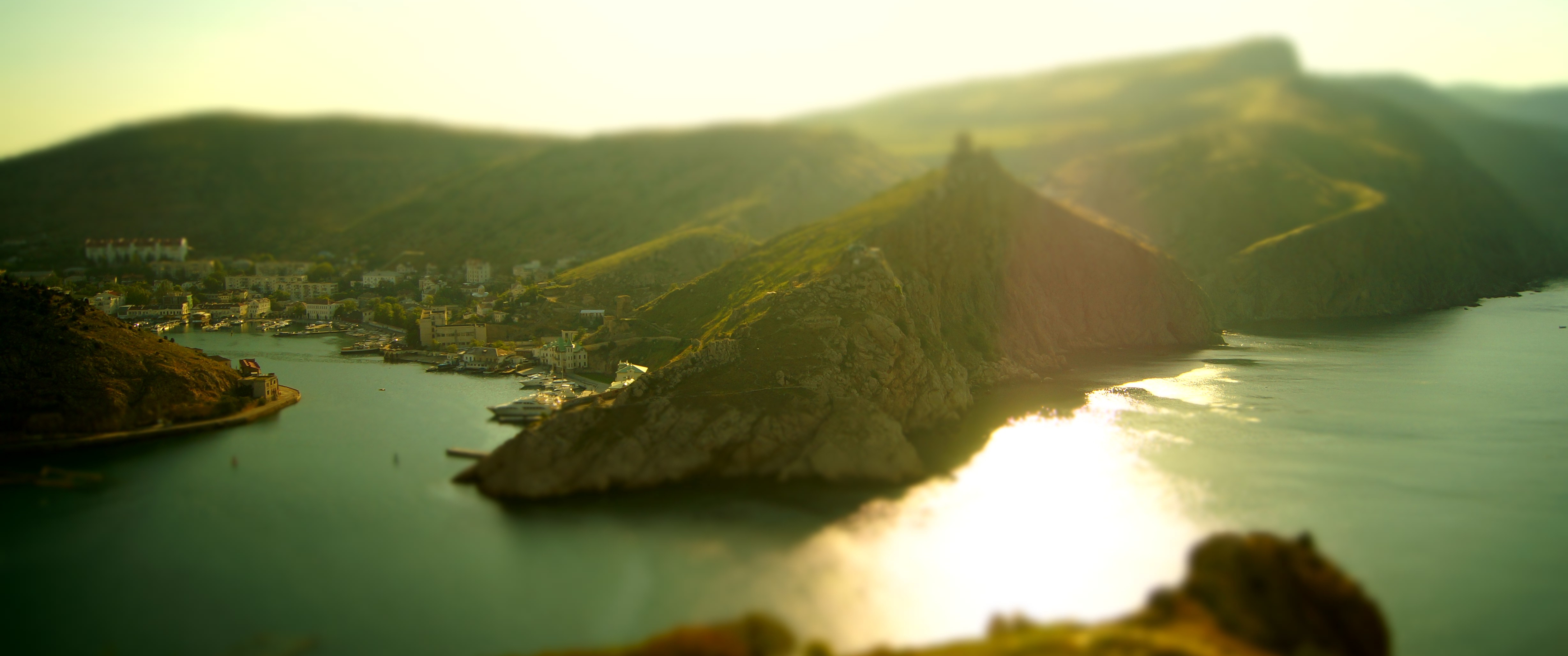Coastal town nestled in a bay with mountains HD Wallpaper