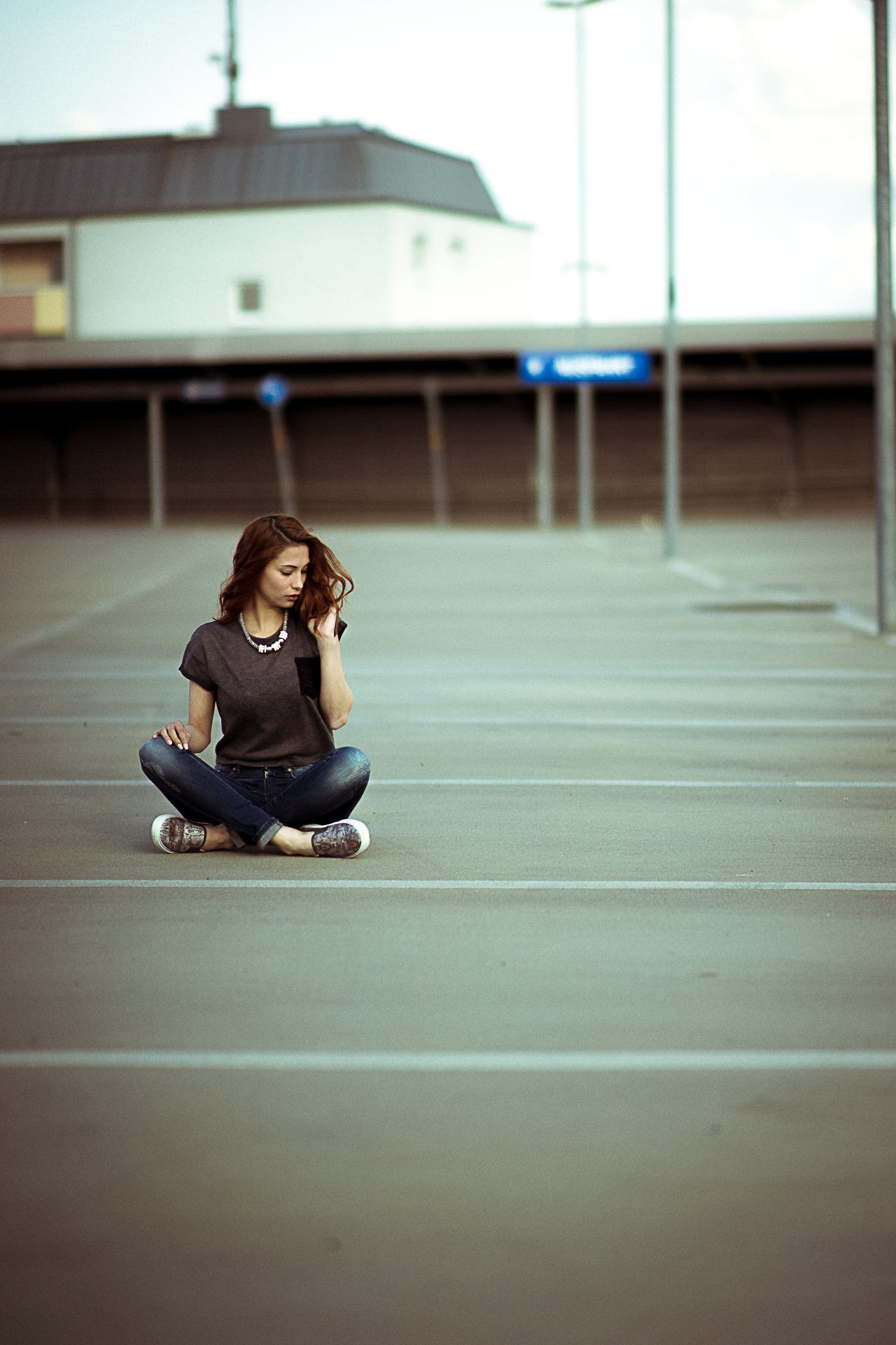 Woman sitting in a parking lot HD Wallpaper