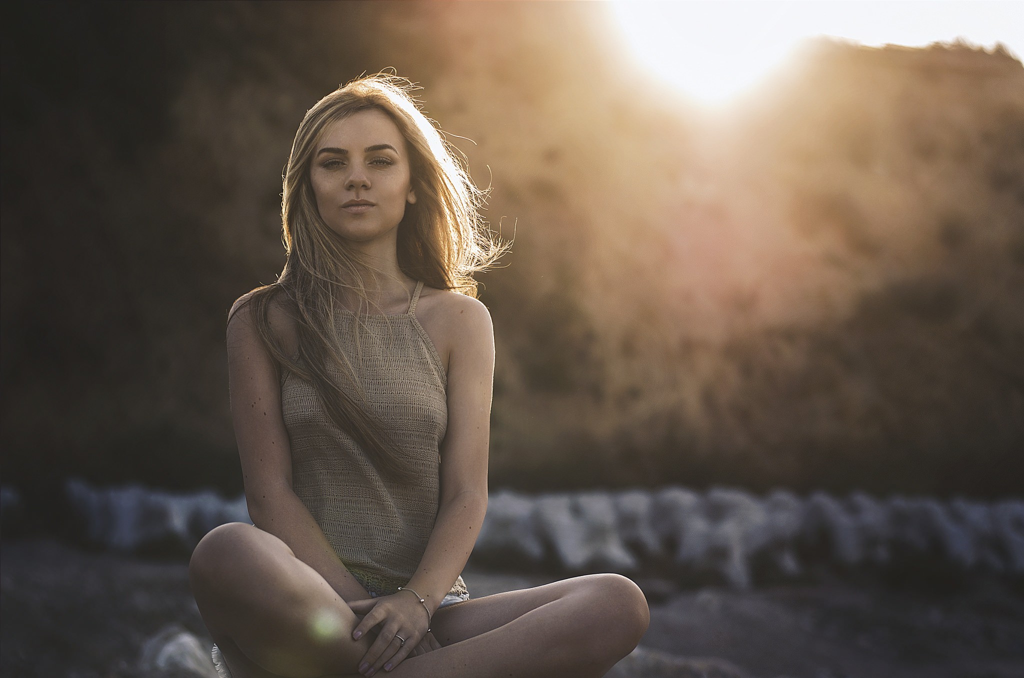 Woman sitting outdoors with sun flare HD Wallpaper